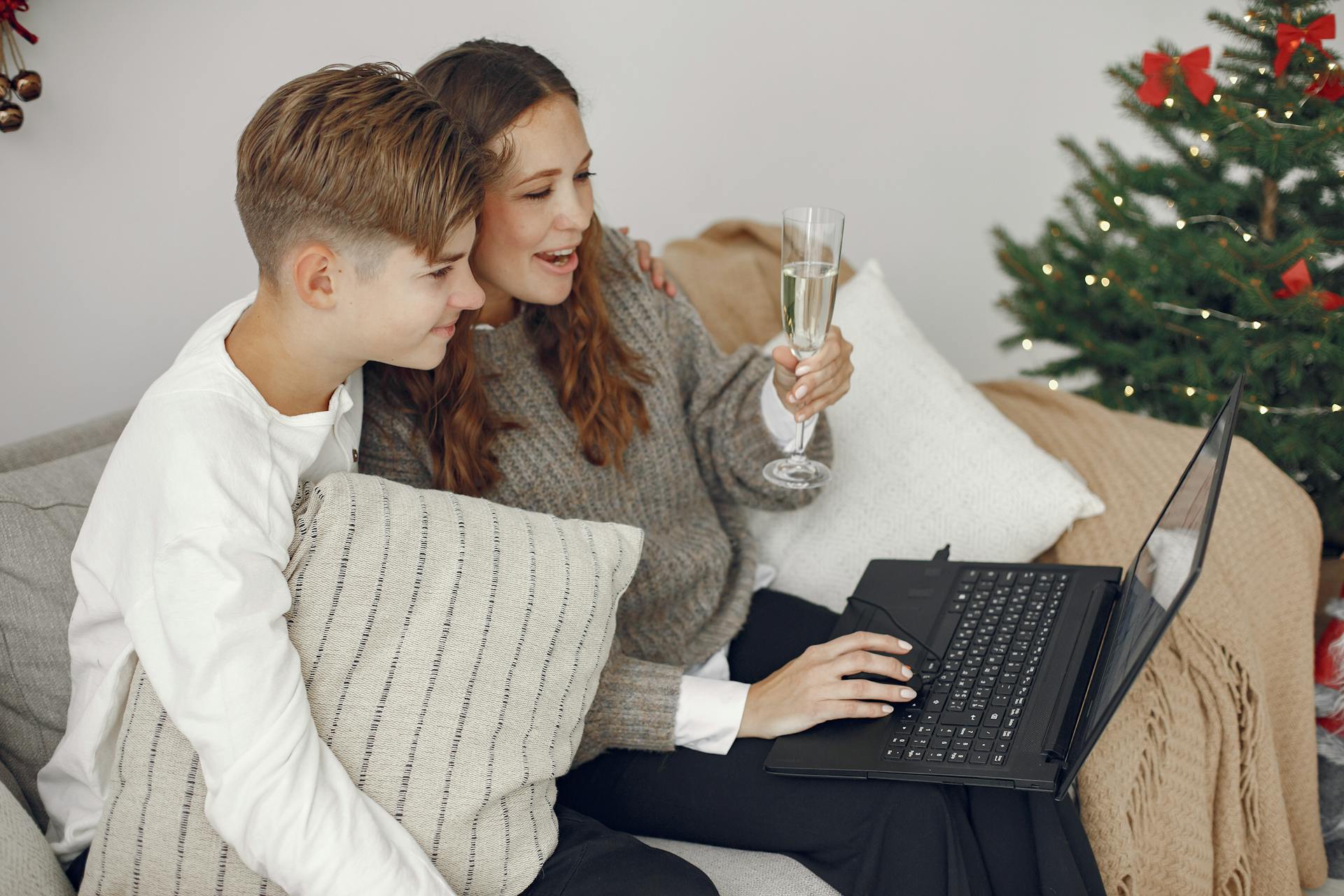 Une femme et son jeune fils assis ensemble et regardant l'écran de l'ordinateur portable | Source : Pexels