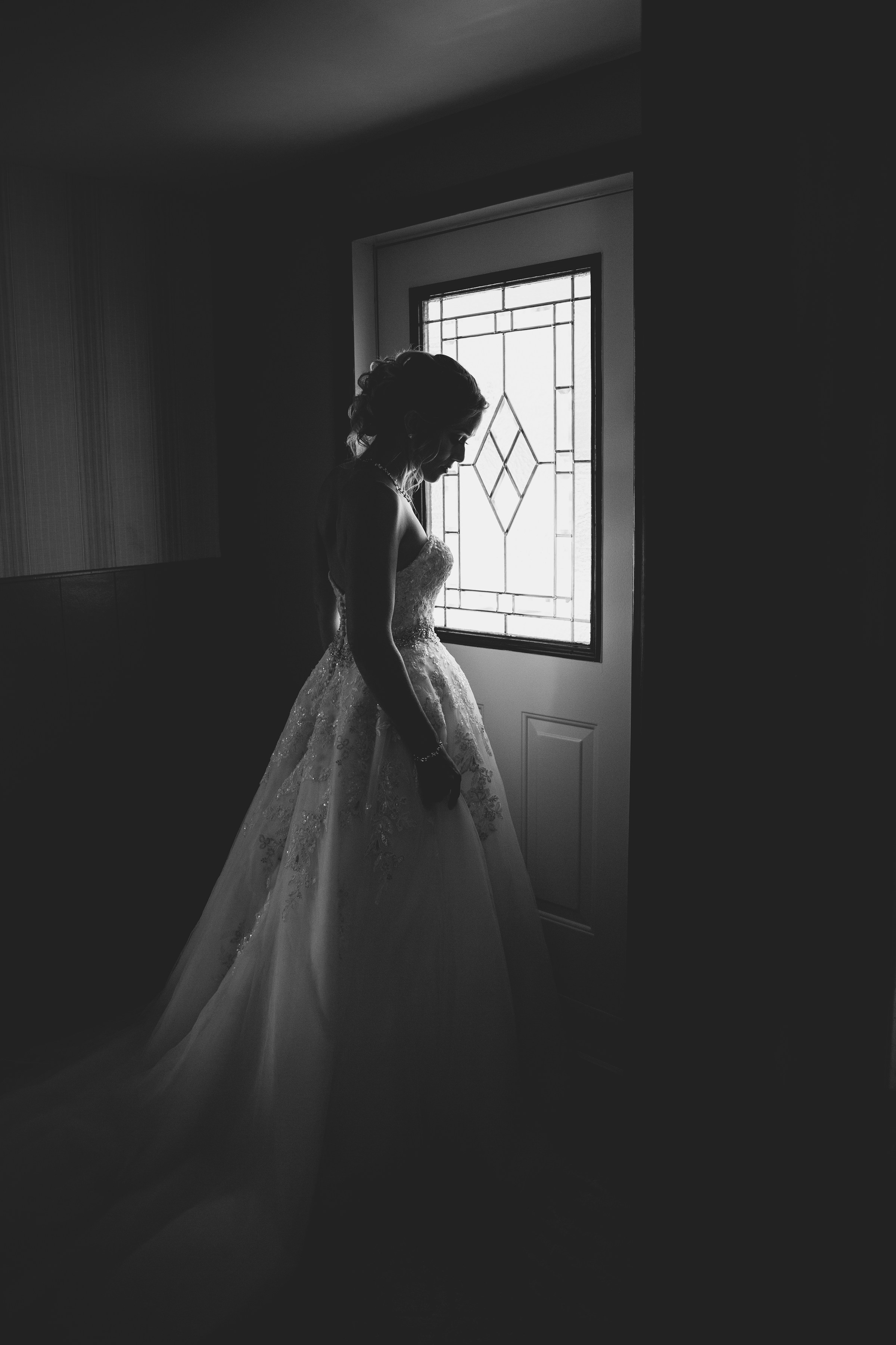 La silhouette d'une mariée debout derrière une porte | Source : Unsplash