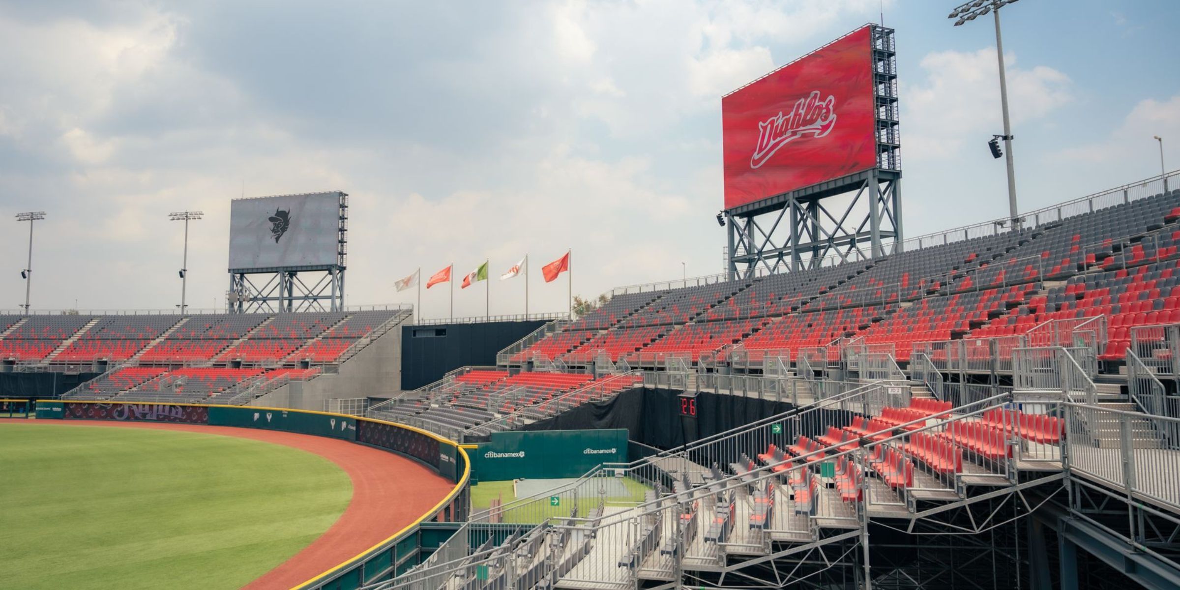 Un stade vide avec des sièges rouges et un grand tableau d'affichage | Source : Pexels