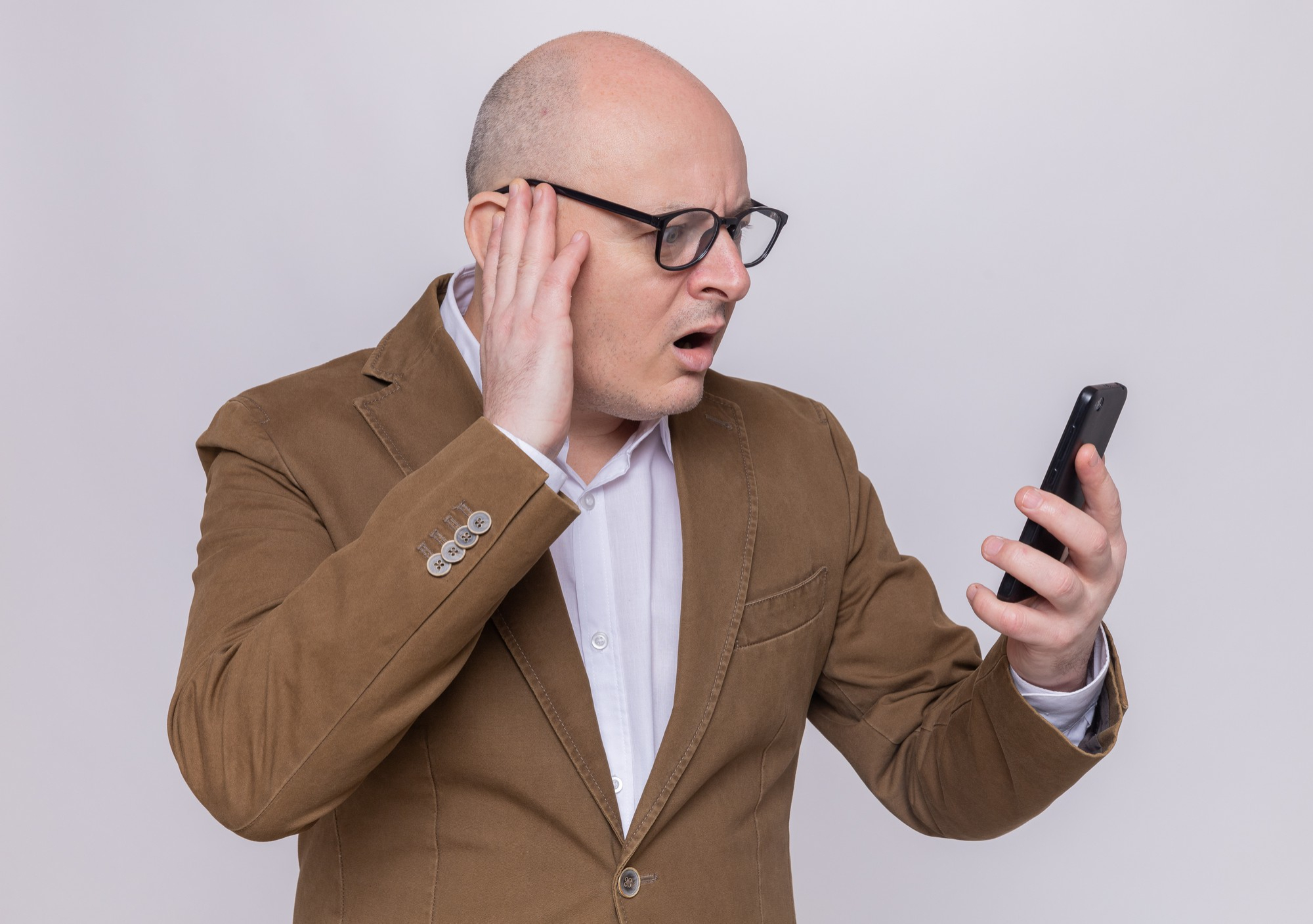 Un homme bouleversé et choqué écoutant un enregistrement sur son téléphone | Source : Pexels
