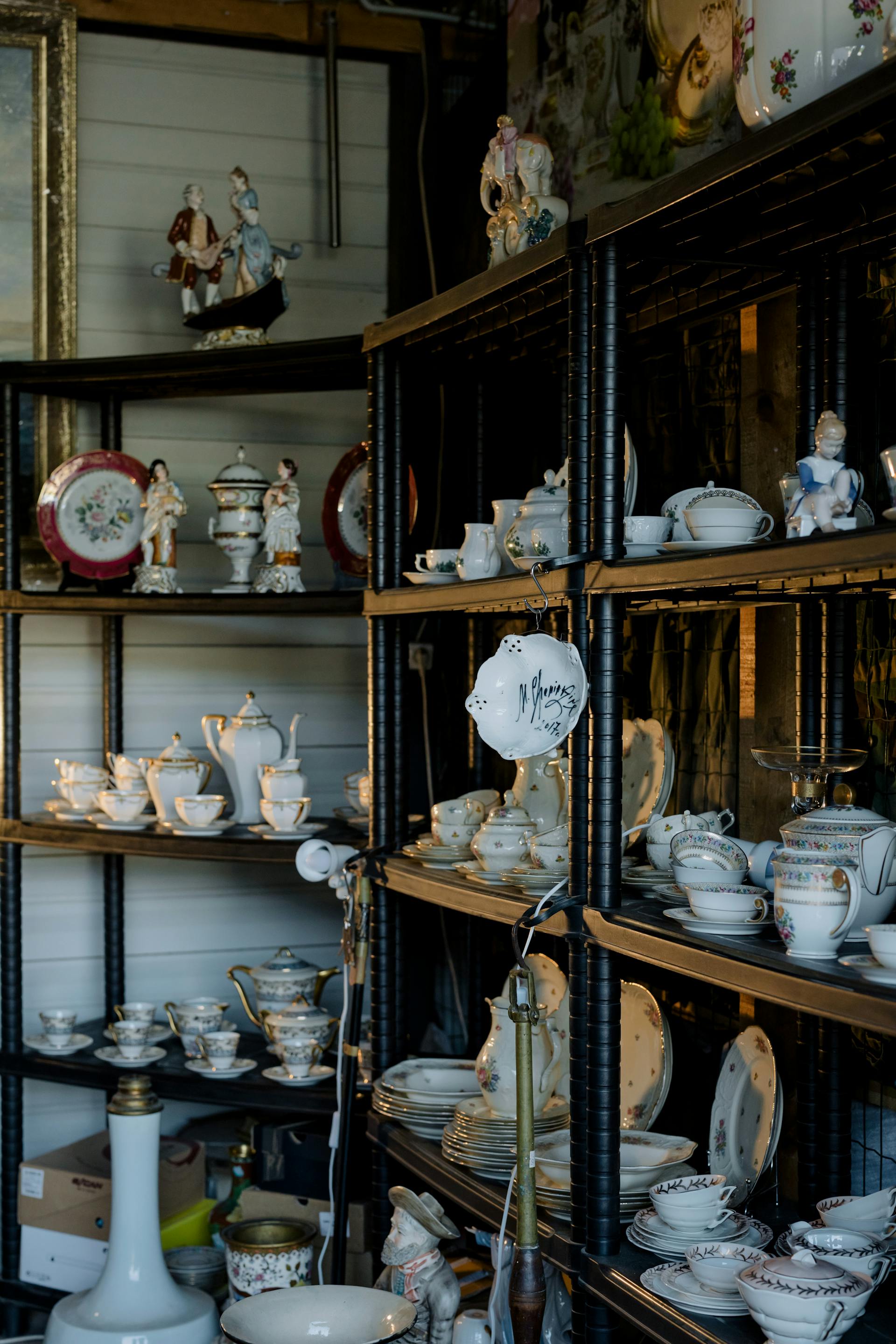 Ceramic figurines and tableware on shelves | Source: Pexels