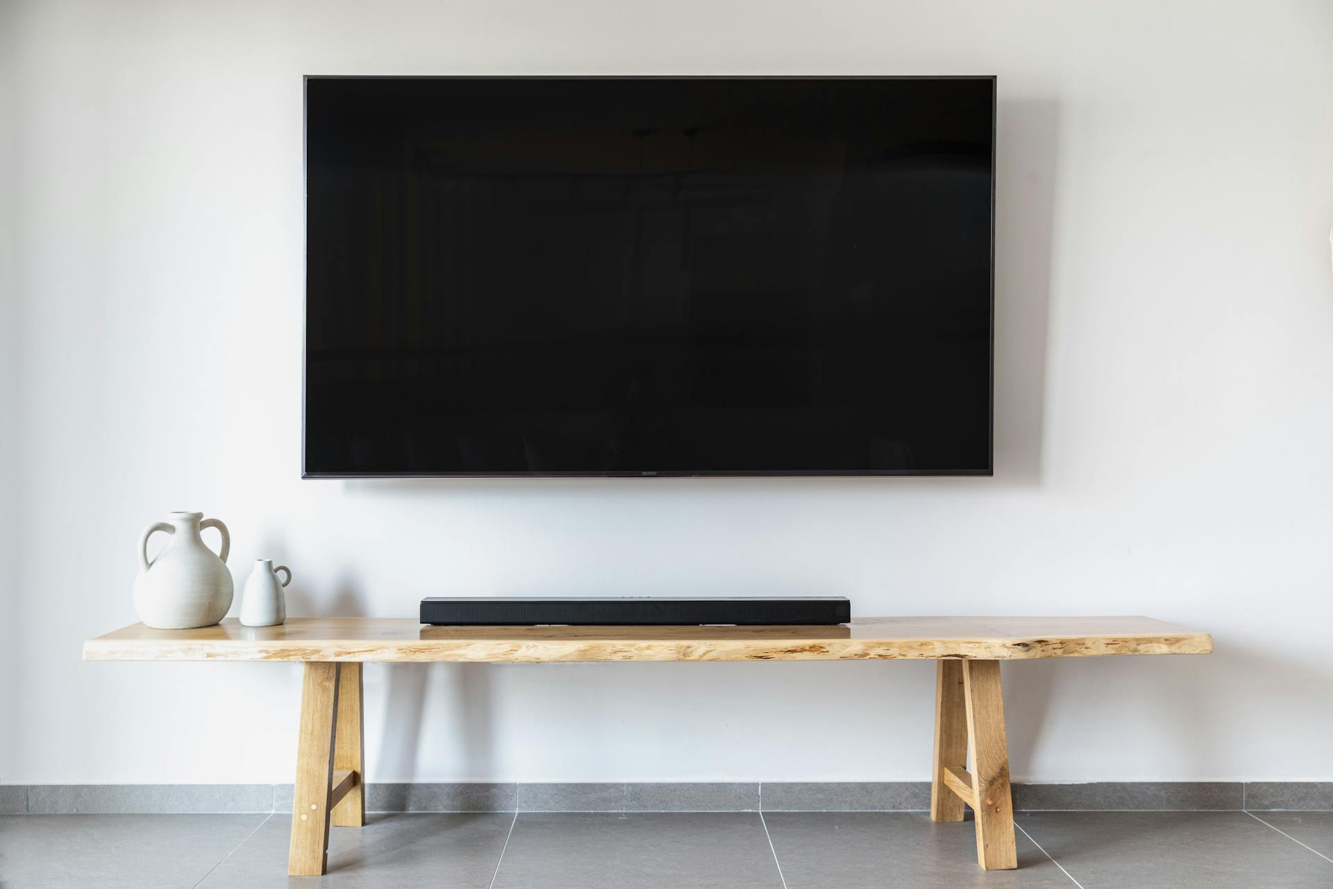 Un téléviseur à écran plat fixé au mur dans une pièce | Source : Pexels