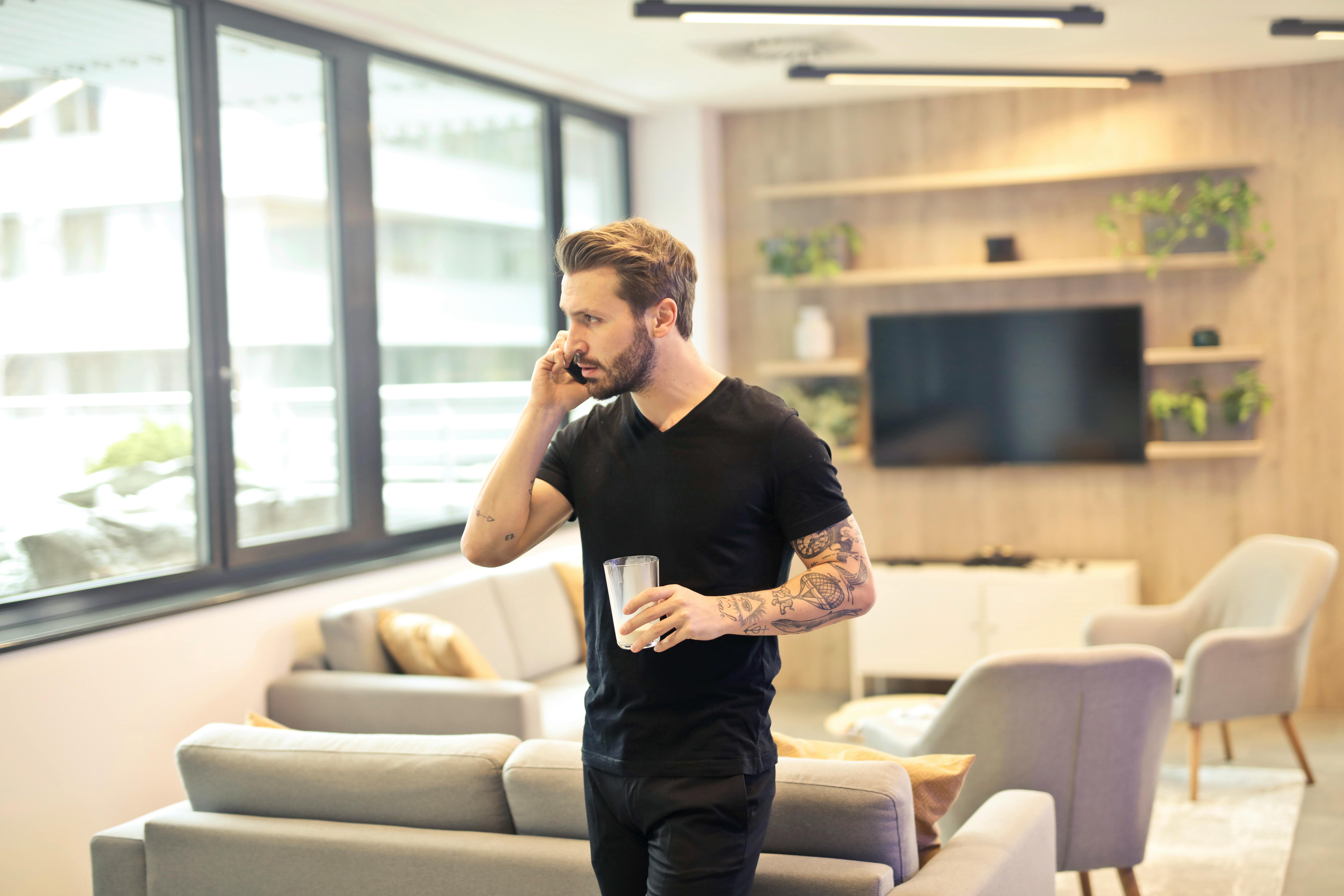 Un homme tenant une boisson tout en parlant au téléphone | Source : Pexels