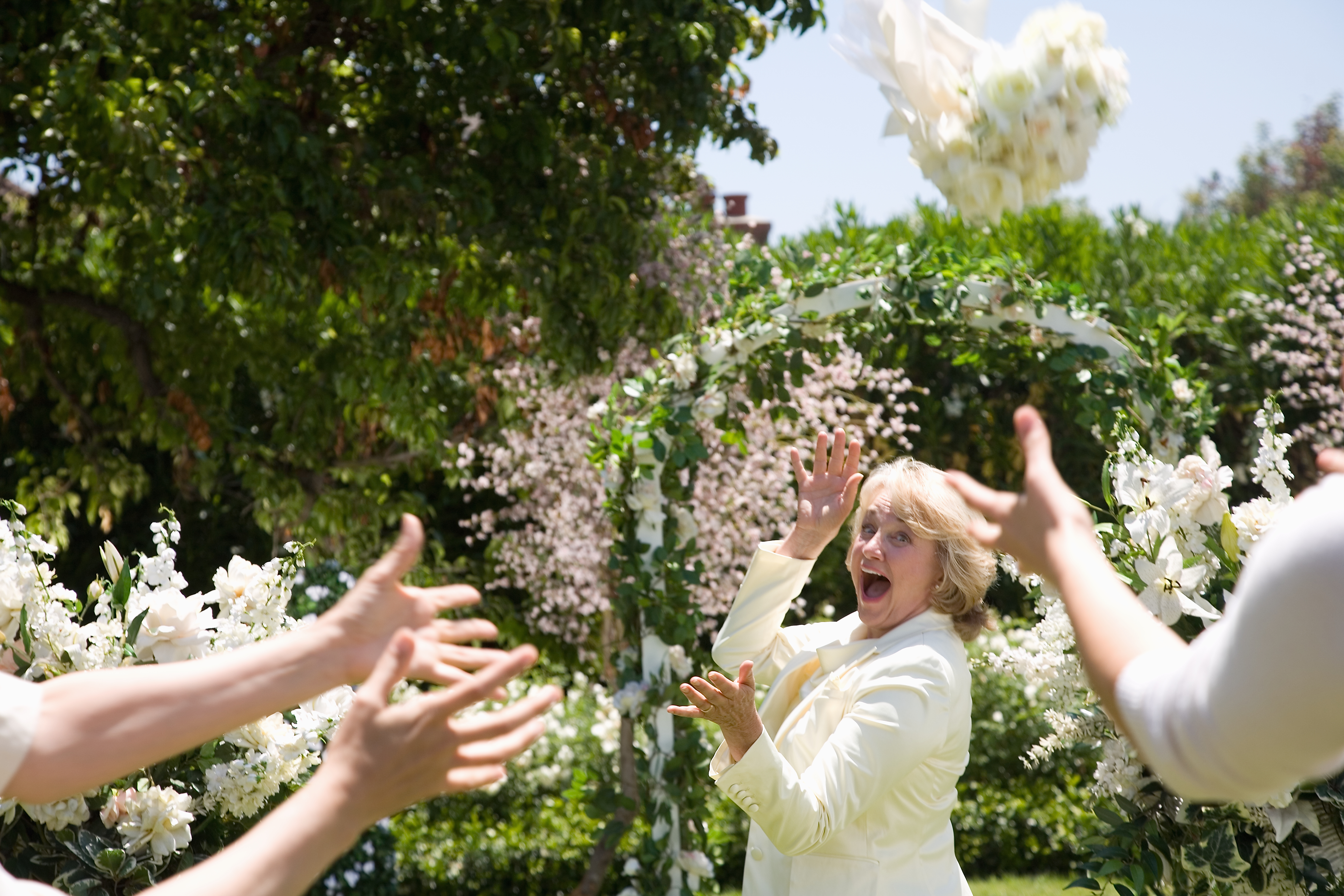 La mariée jette un bouquet de fleurs en riant | Source : Getty Images