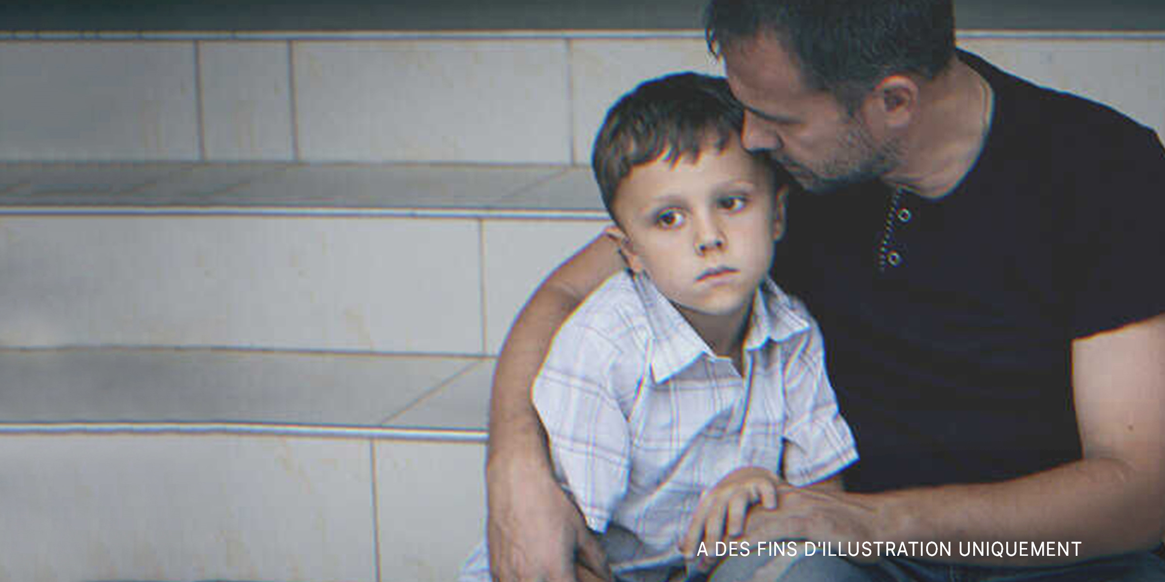 Un homme serrant son fils dans ses bras | Photo : Shutterstock