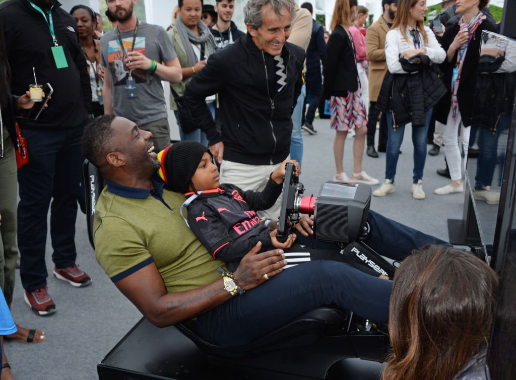 (De gauche à droite) Idris Elba conduit un simulateur avec son fils Winston Elba et Alain Prost assistent au ABB FIA Formula E Qatar Airways Paris E-Prix 2018 le 28 avril 2018 à Paris, France | Photo : Getty Images