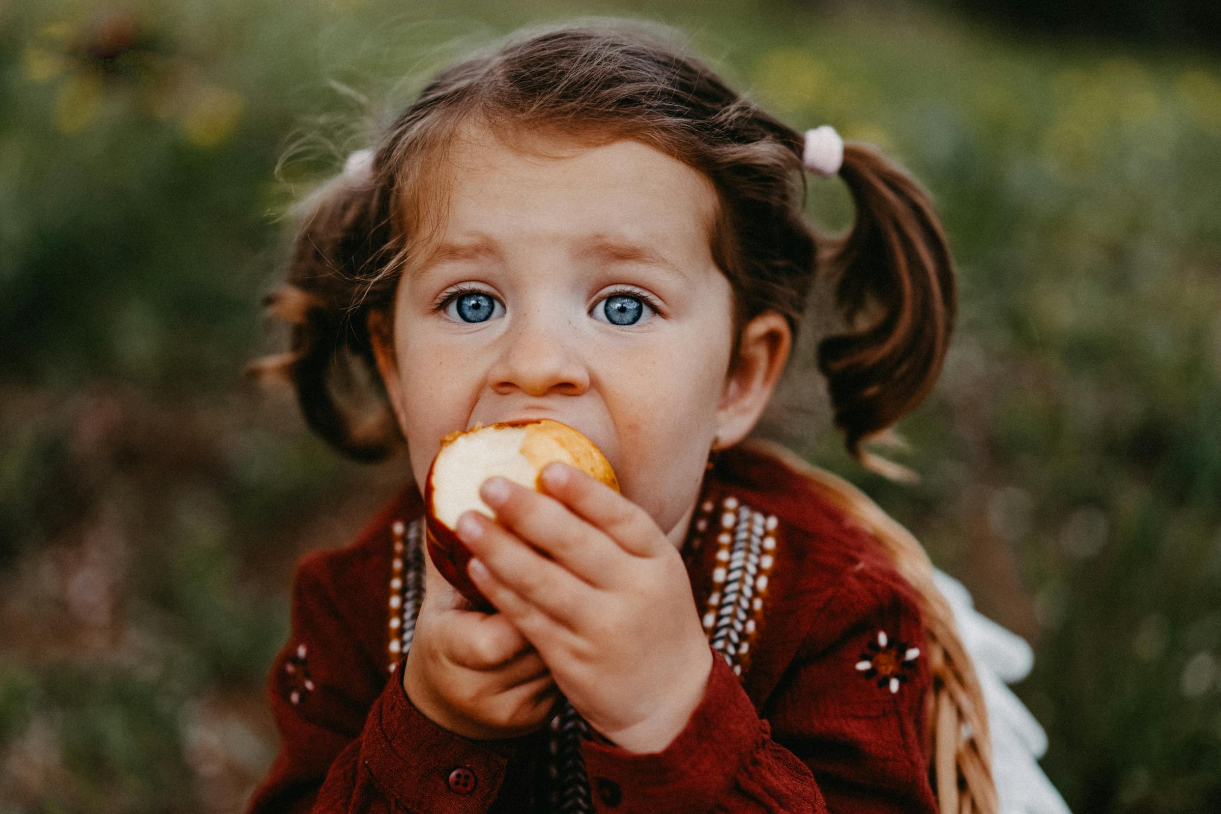 Une fille mangeant une pomme | Source : Pexels