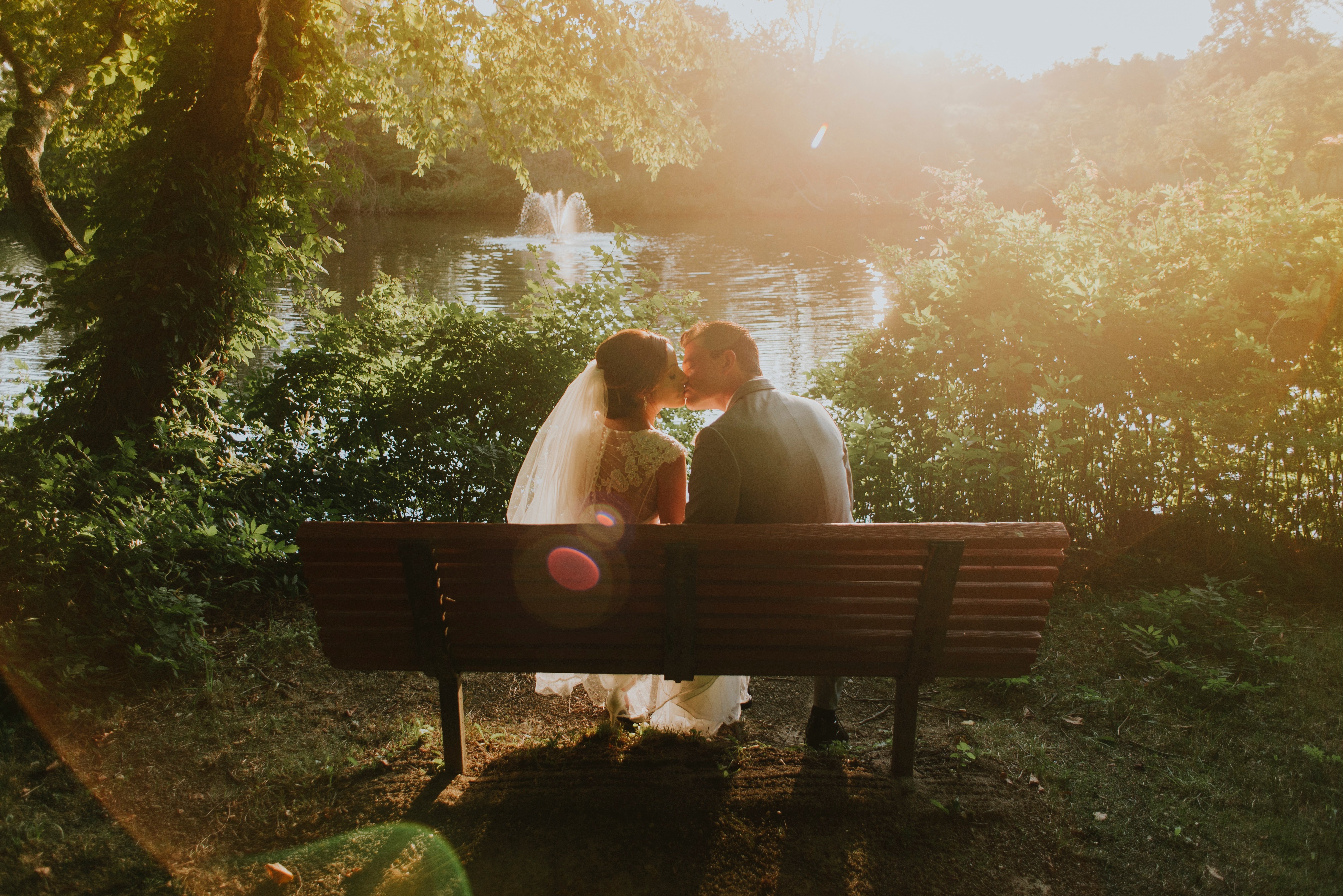 Un couple marié qui s'embrasse sur un banc. l Source: Unsplash