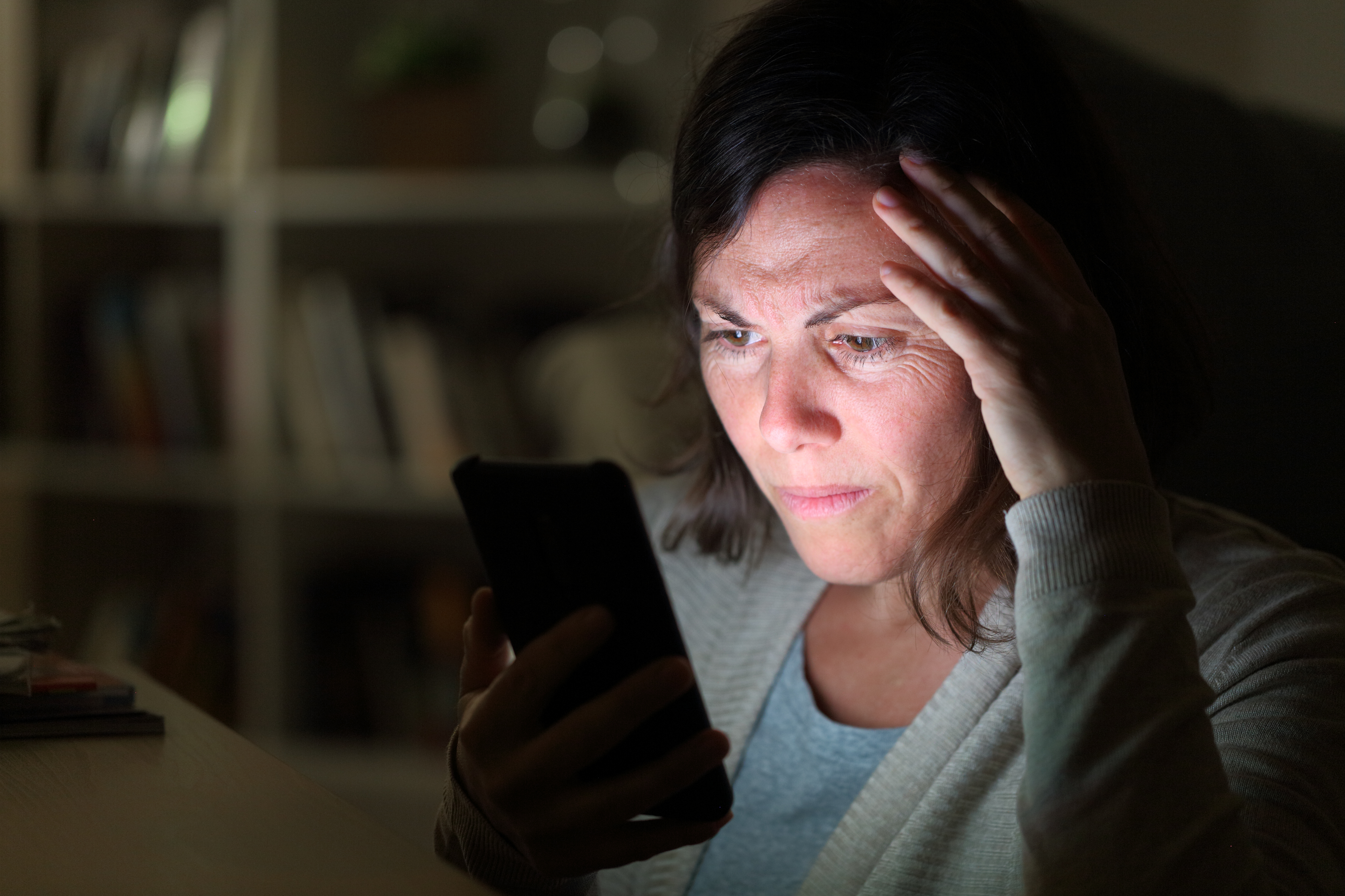 Une femme inquiète regarde son téléphone portable | Source : Shutterstock