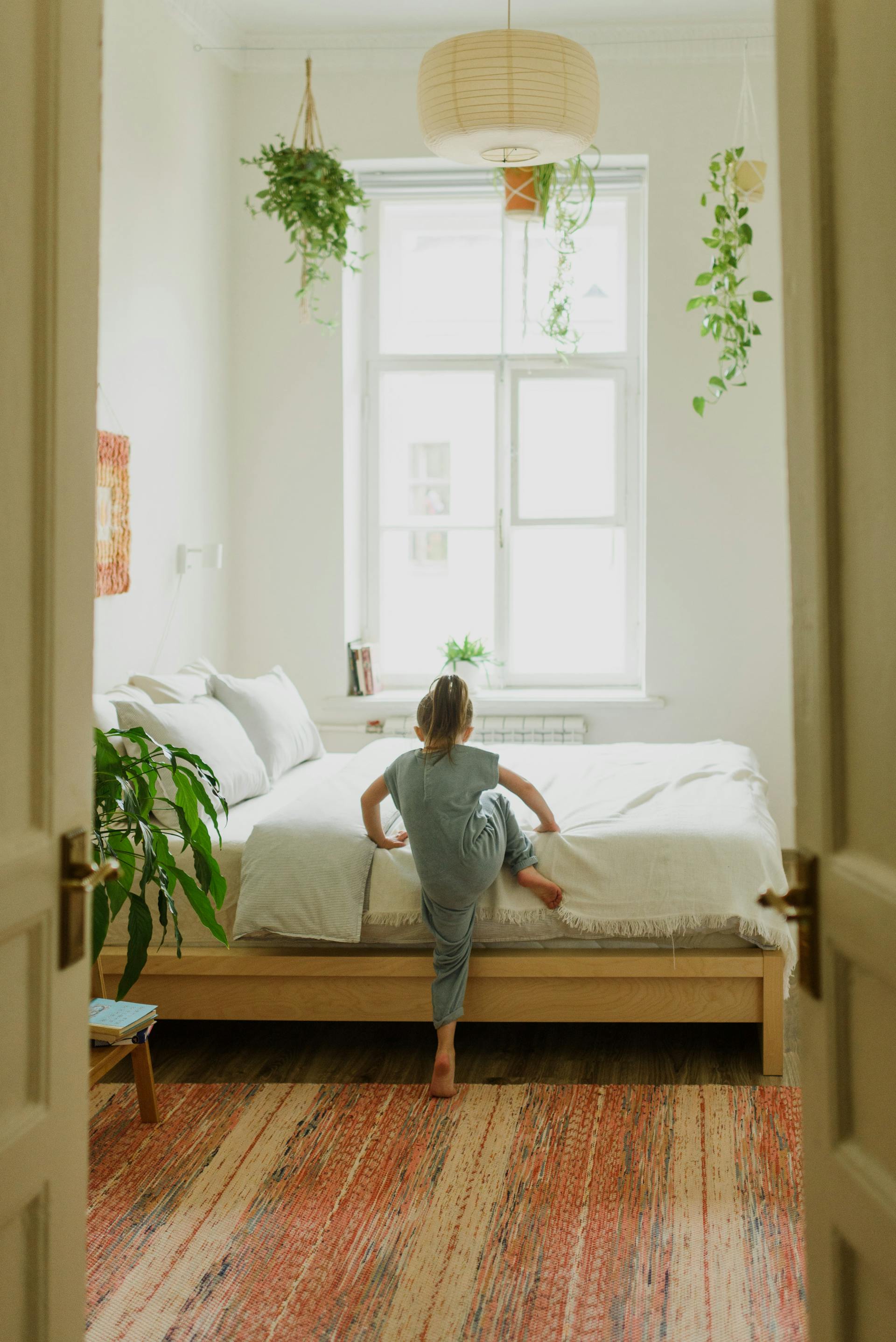 Une petite fille qui grimpe dans son lit | Source : Pexels