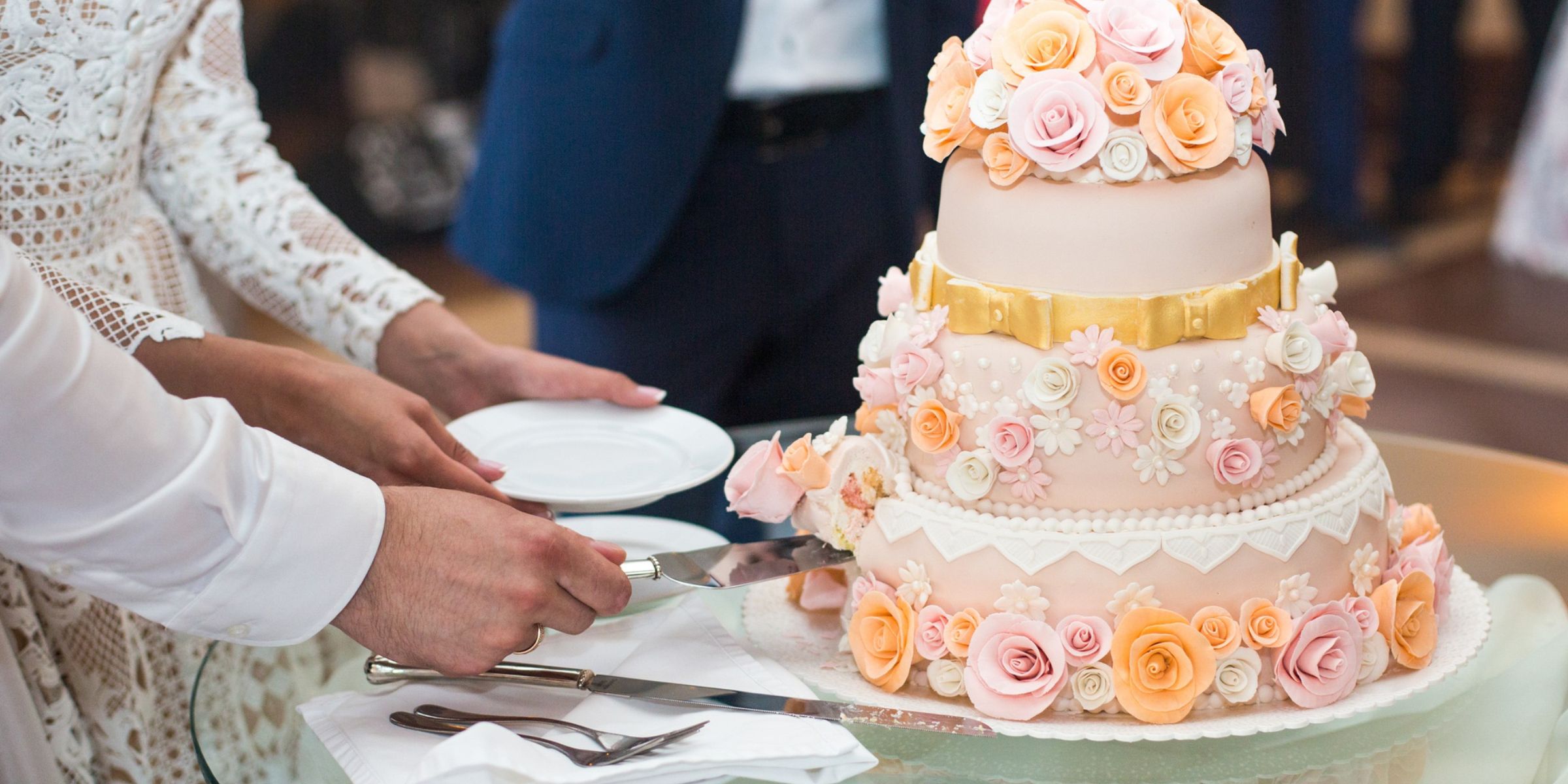 Des mariés en train de couper leur gâteau de mariage | Source : Magnific