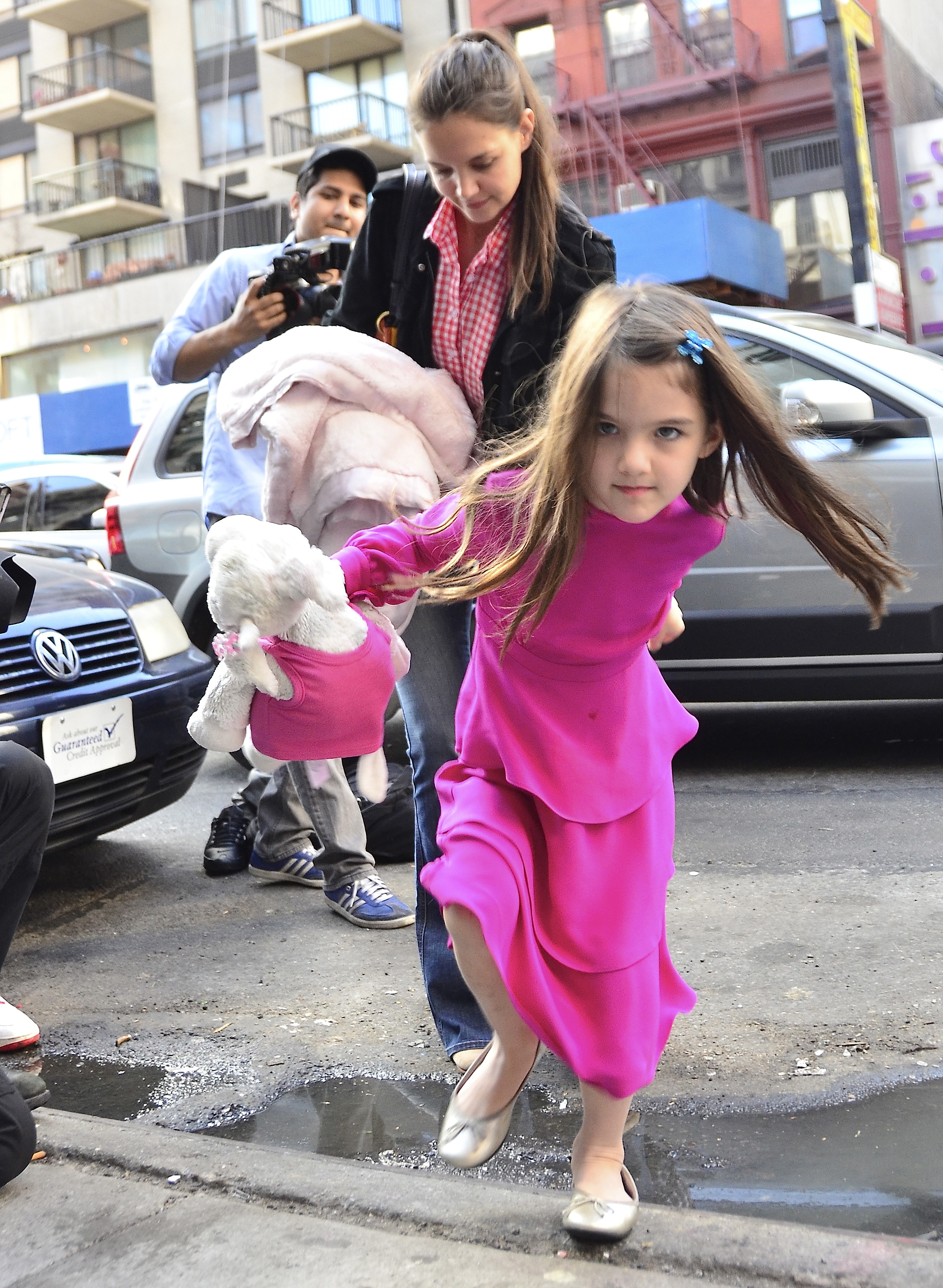 Katie Holmes et Suri Cruise avec un paparazzi en arrière-plan à New York le 20 mars 2012 | Source : Getty Images