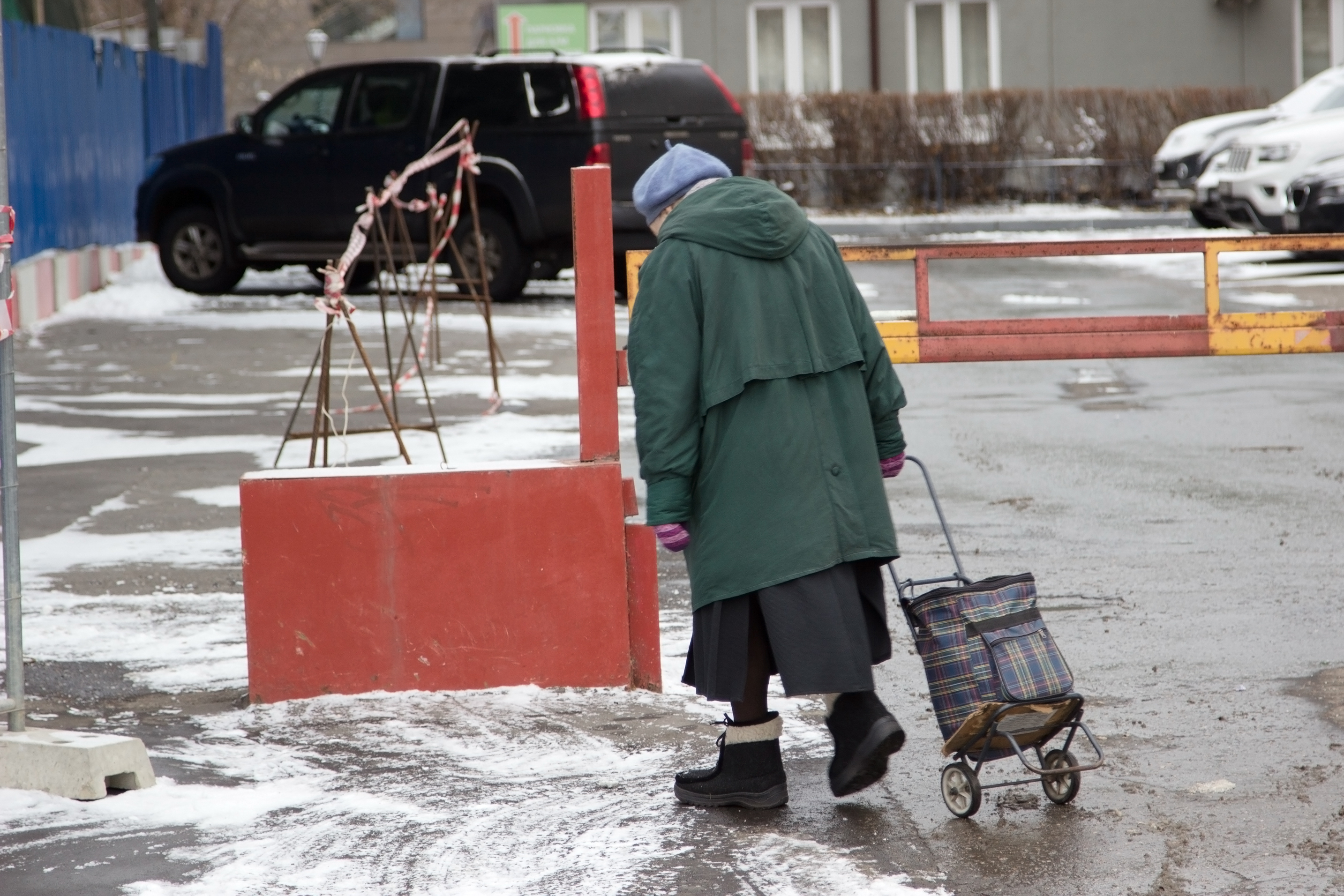 Une femme âgée solitaire marchant dans une rue enneigée | Source : Shutterstock