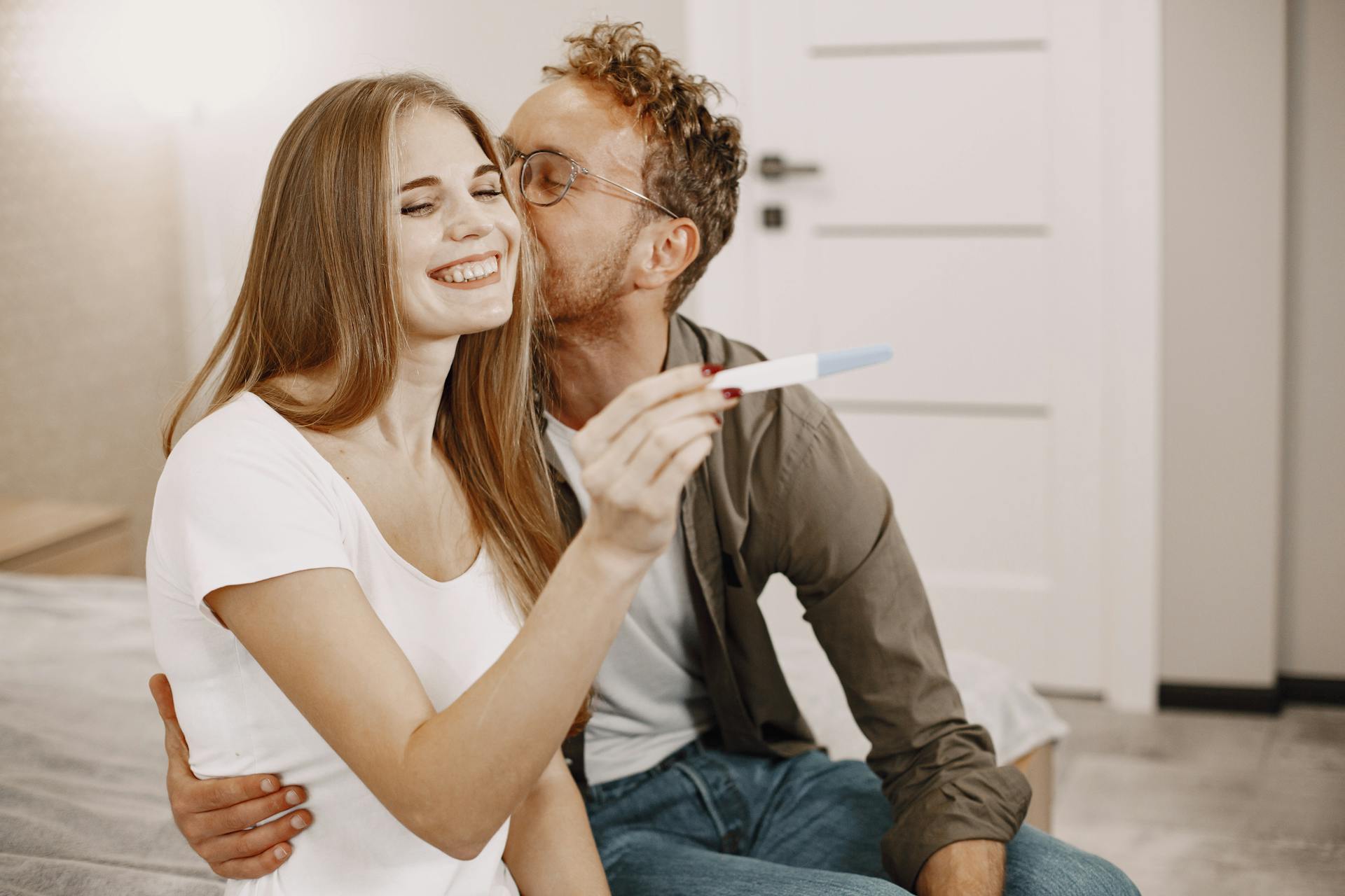 Un homme embrasse une femme sur la joue alors qu'elle révèle sa grossesse | Source : Pexels