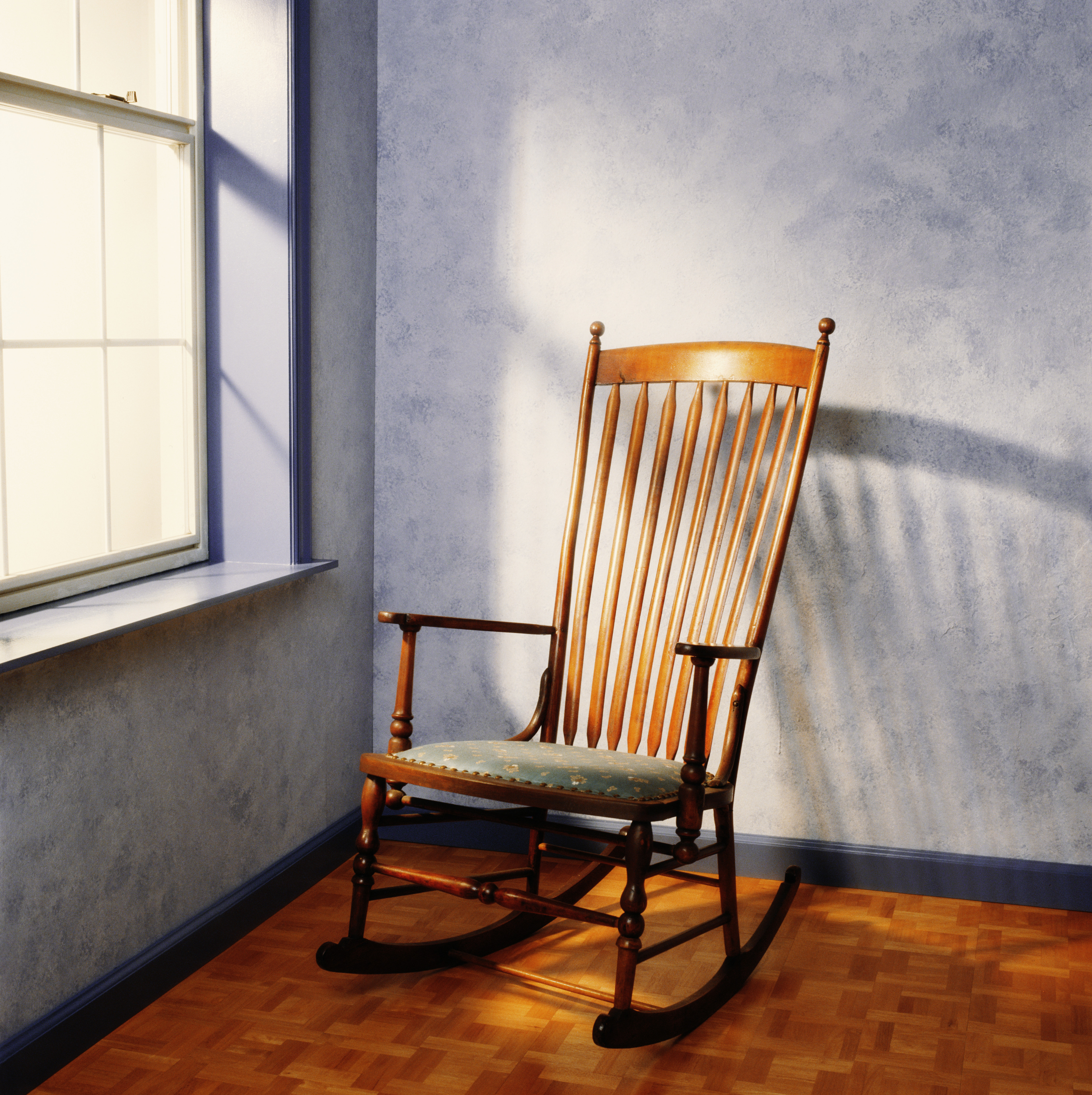 Une chaise à bascule vide près d'une fenêtre | Source : Getty Images