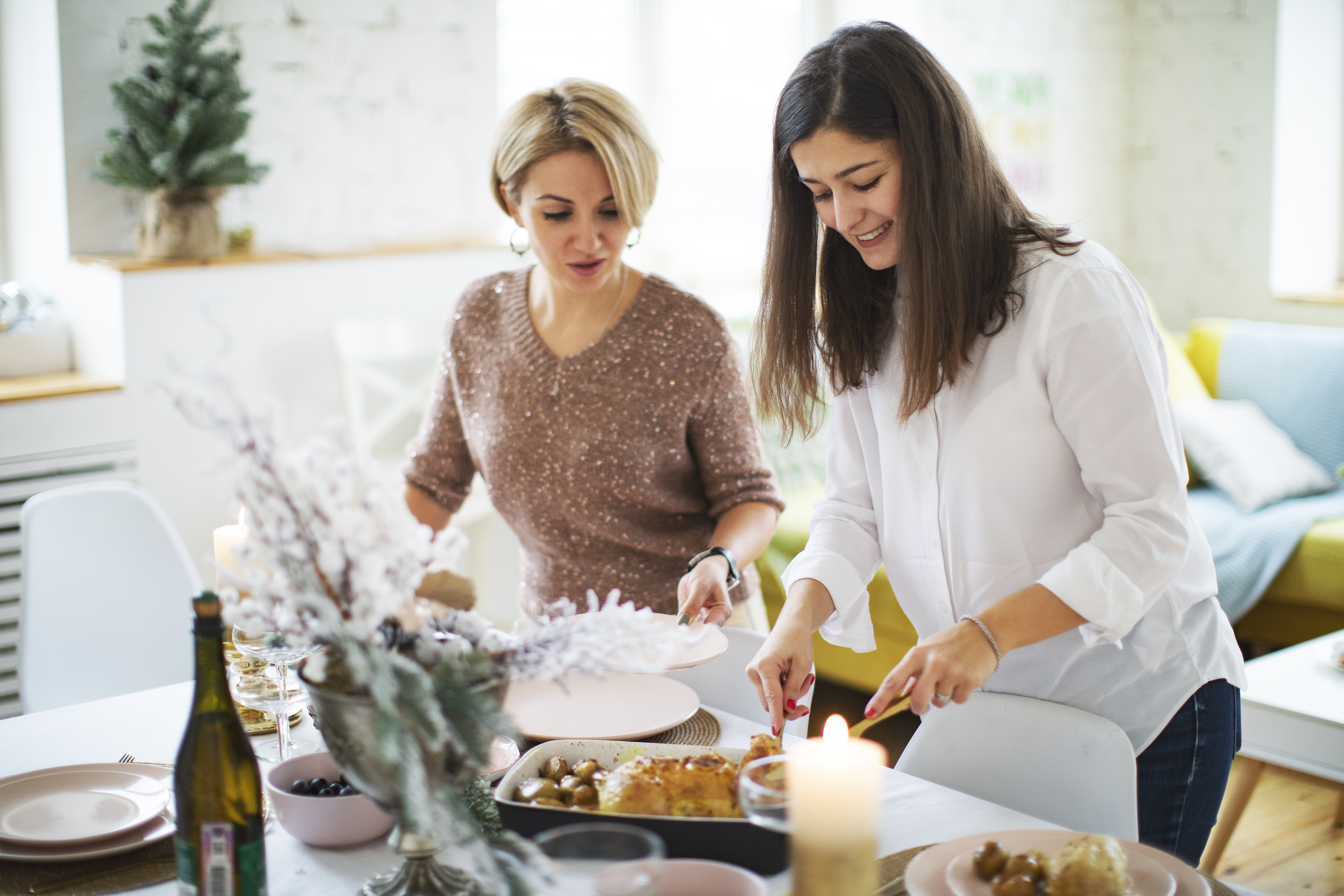 Une femme et ses amis mettent la table avant la célébration de Noël | Source : Getty Images