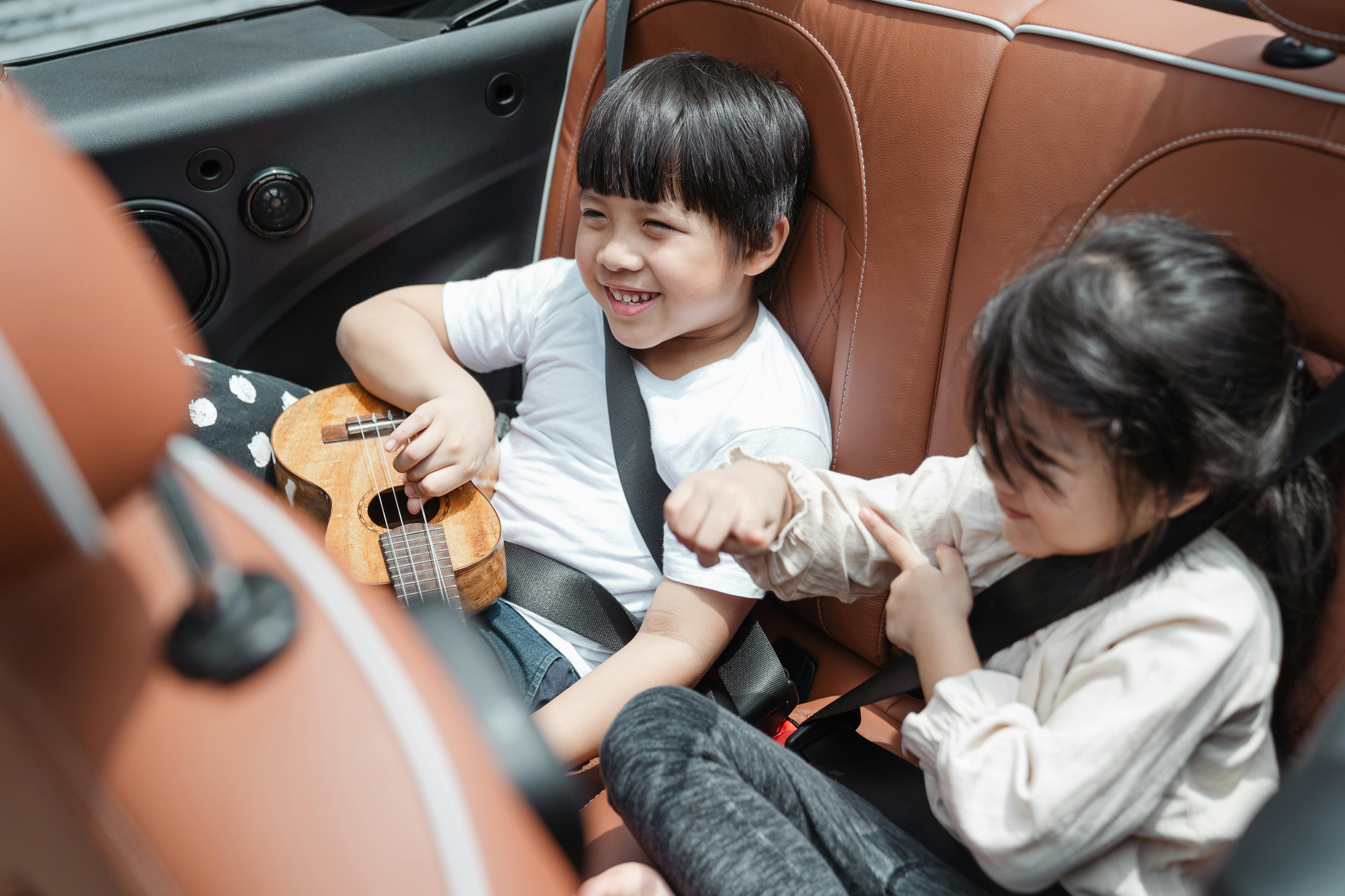 Des enfants excités sur la banquette arrière d'une voiture | Source : Pexels