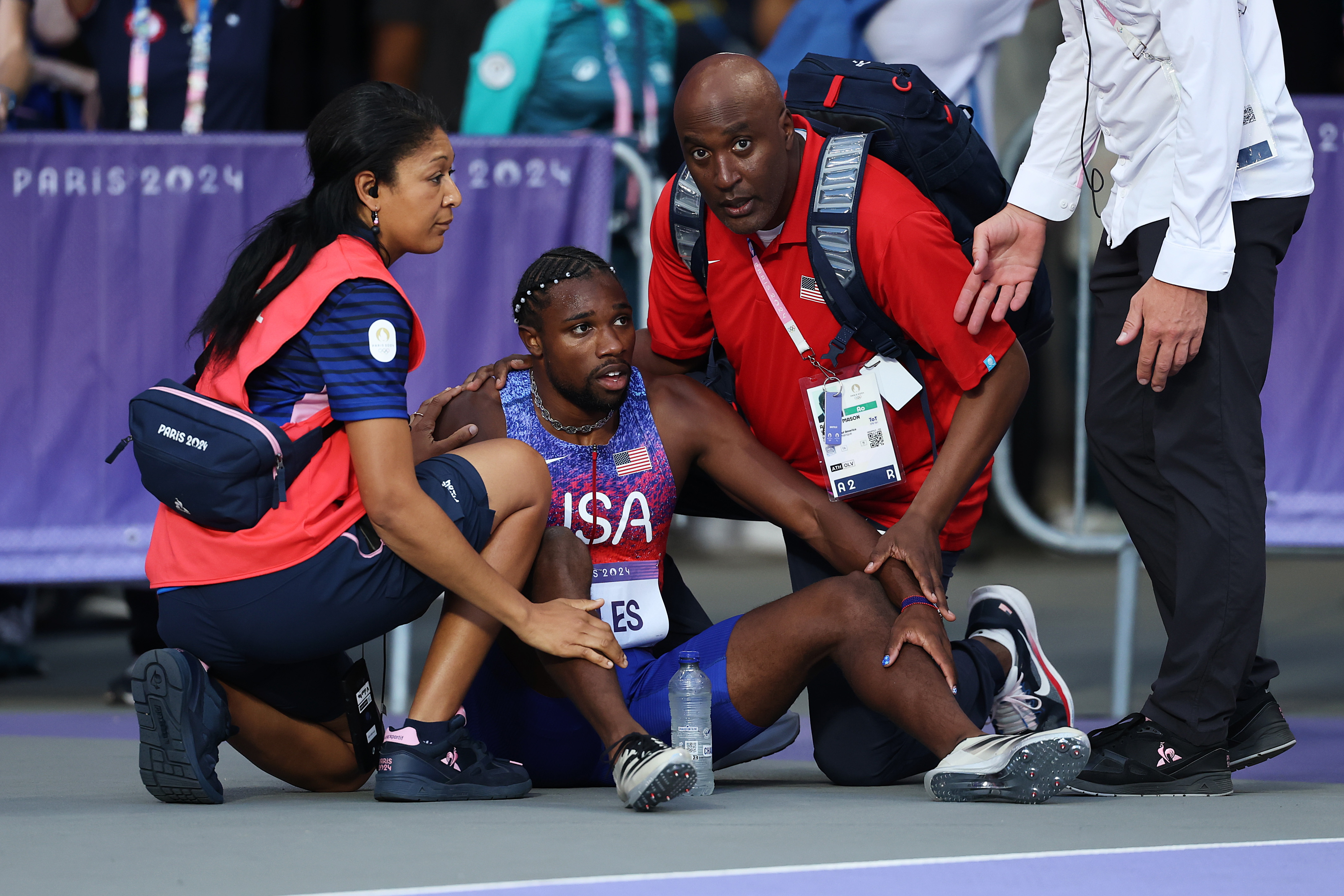 Noah Lyles de l'équipe américaine aidé par le personnel médical après avoir participé à la finale du 200 m masculin aux Jeux olympiques de Paris le 8 août 2024 | Source : Getty Images