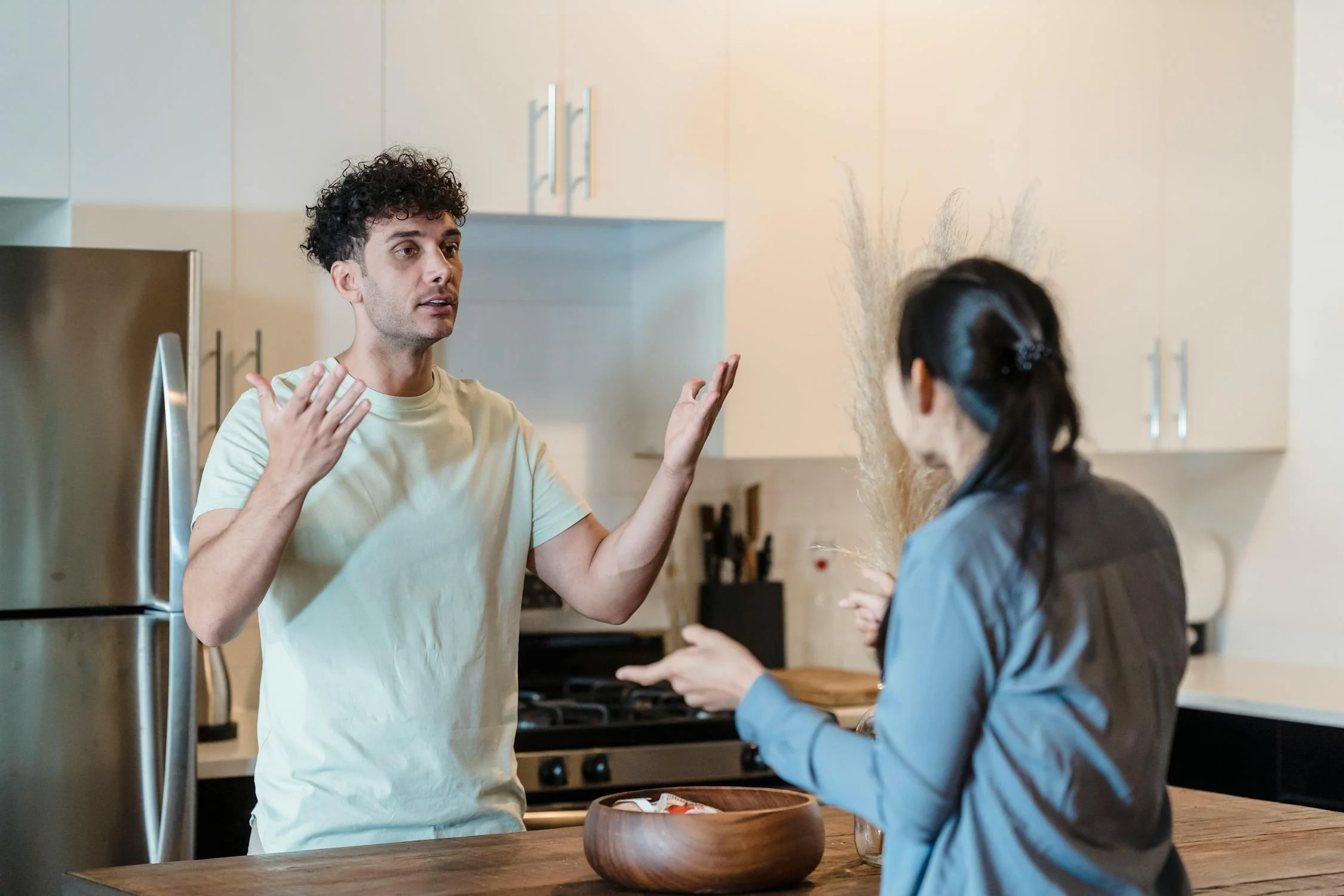 Un homme qui parle à sa femme dans sa cuisine | Source : Pexels