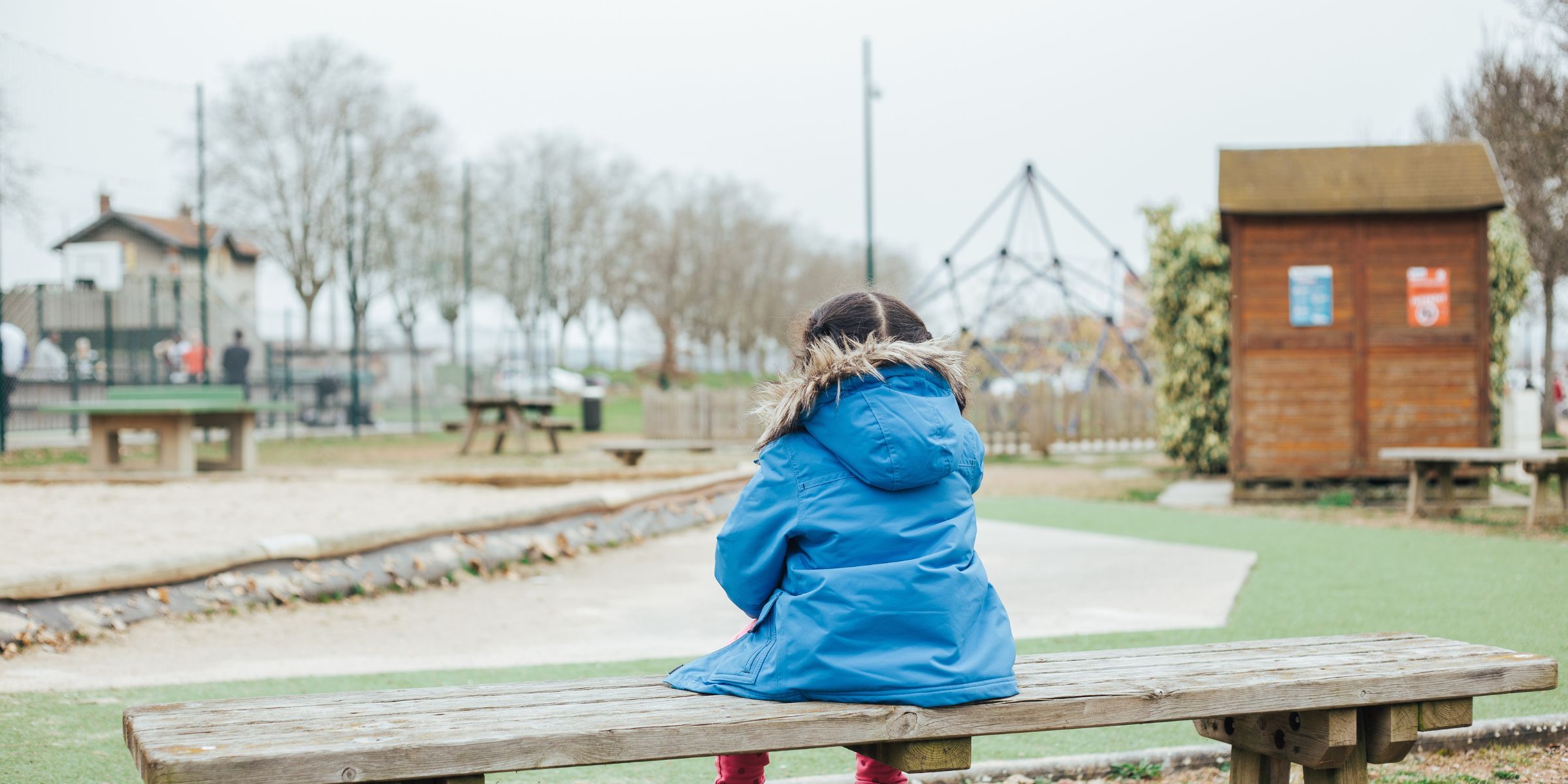 Une fille assise sur un banc dans un parc | Source : Shutterstock