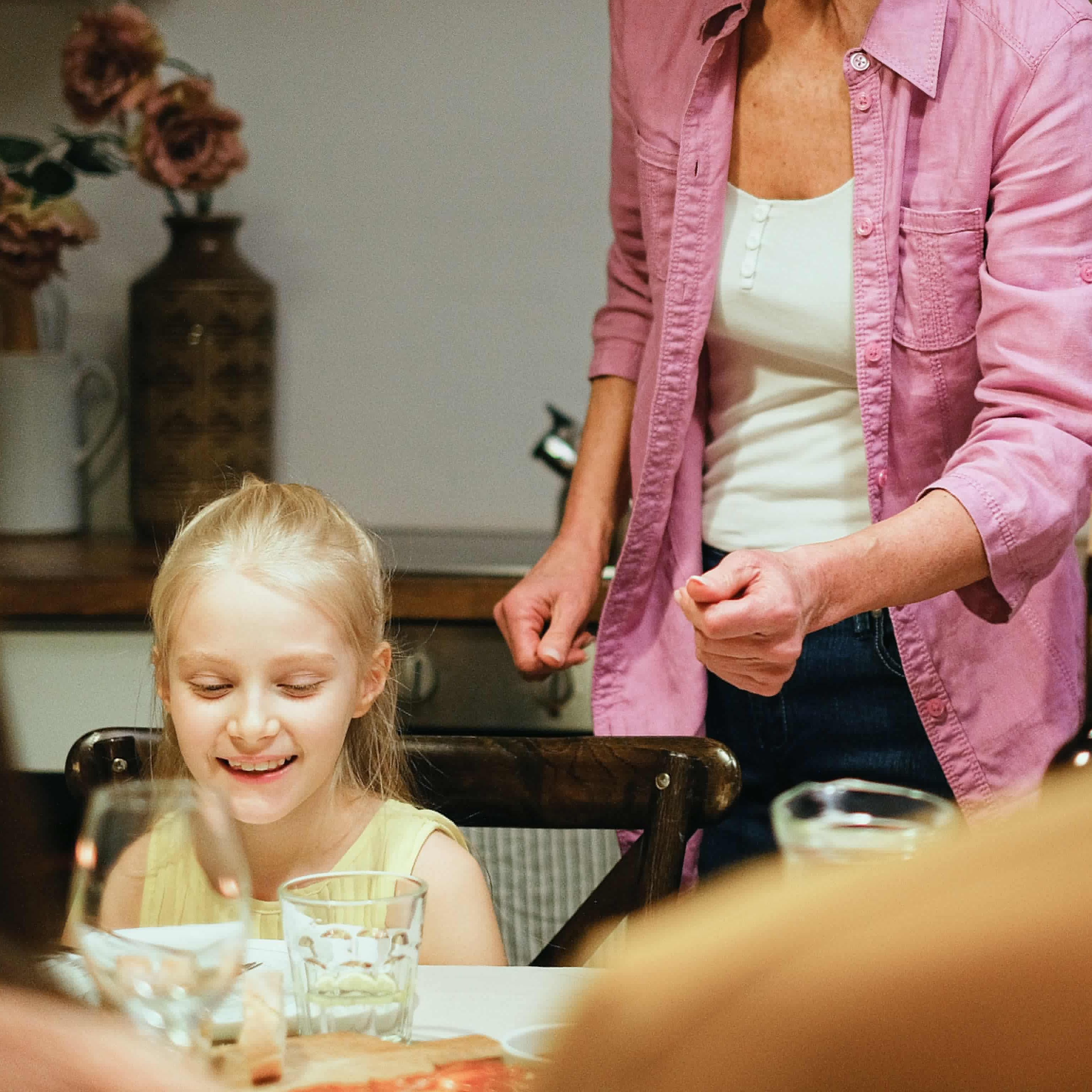 Une femme prépare le dîner pour des enfants à une table | Source : Pexels