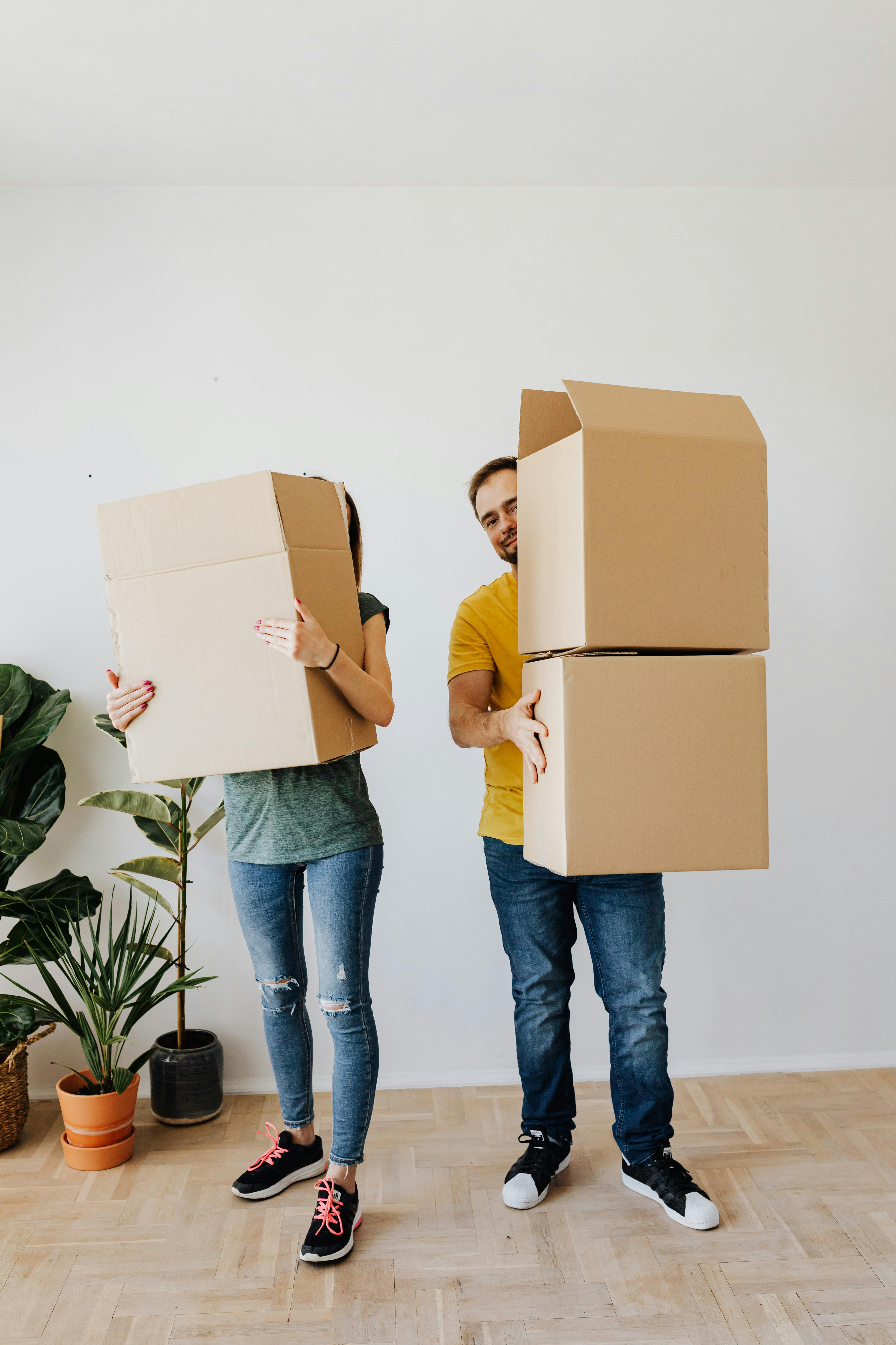 Un couple tenant des cartons prêts à déménager | Source : Pexels