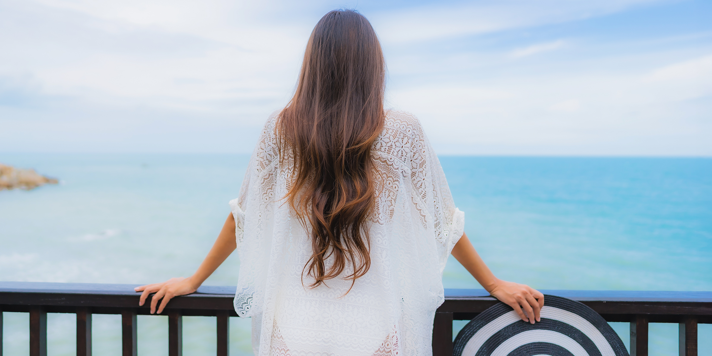 Une femme qui regarde l'océan depuis un balcon | Source : Shutterstock