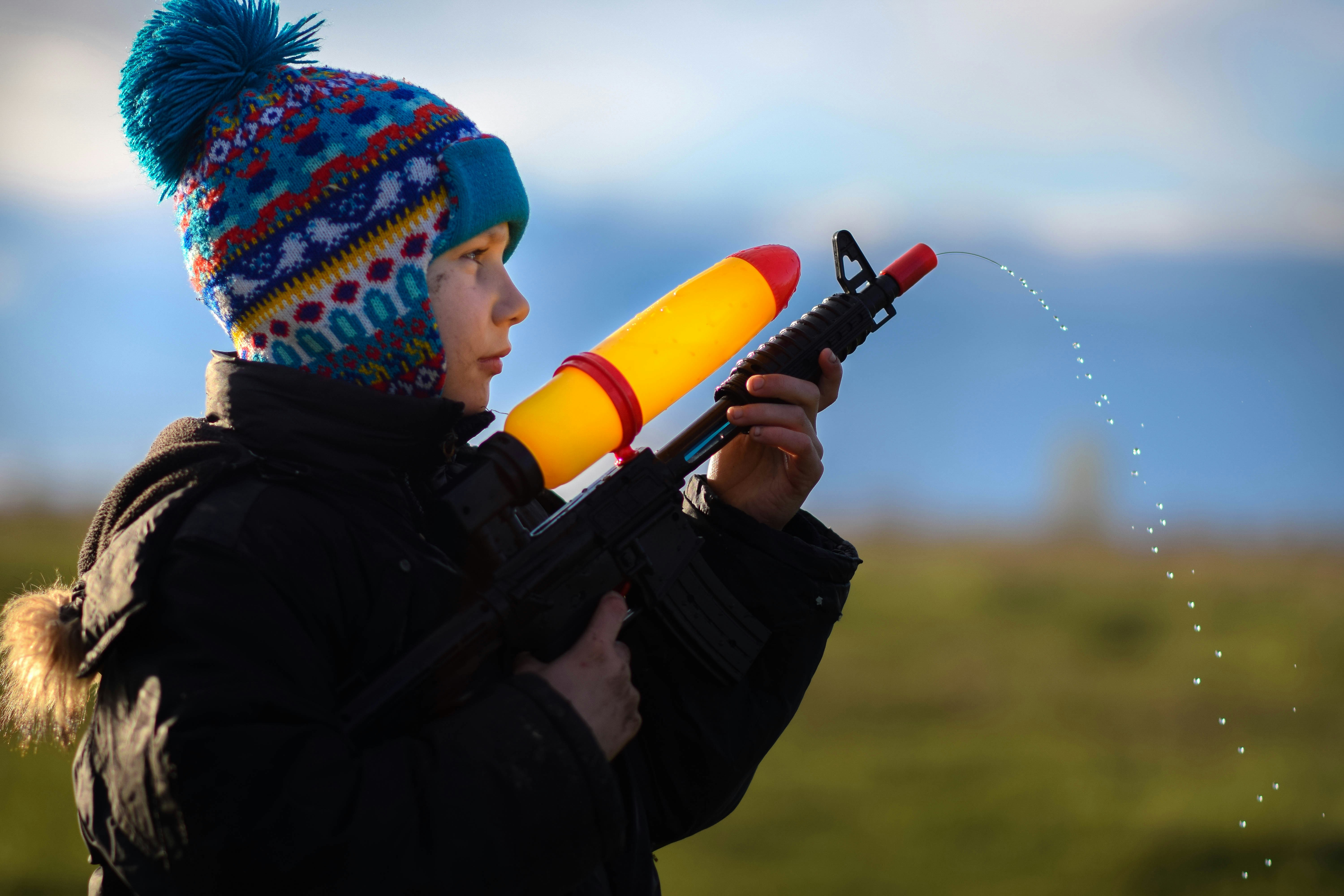 A boy with water guns | Source: Unsplash