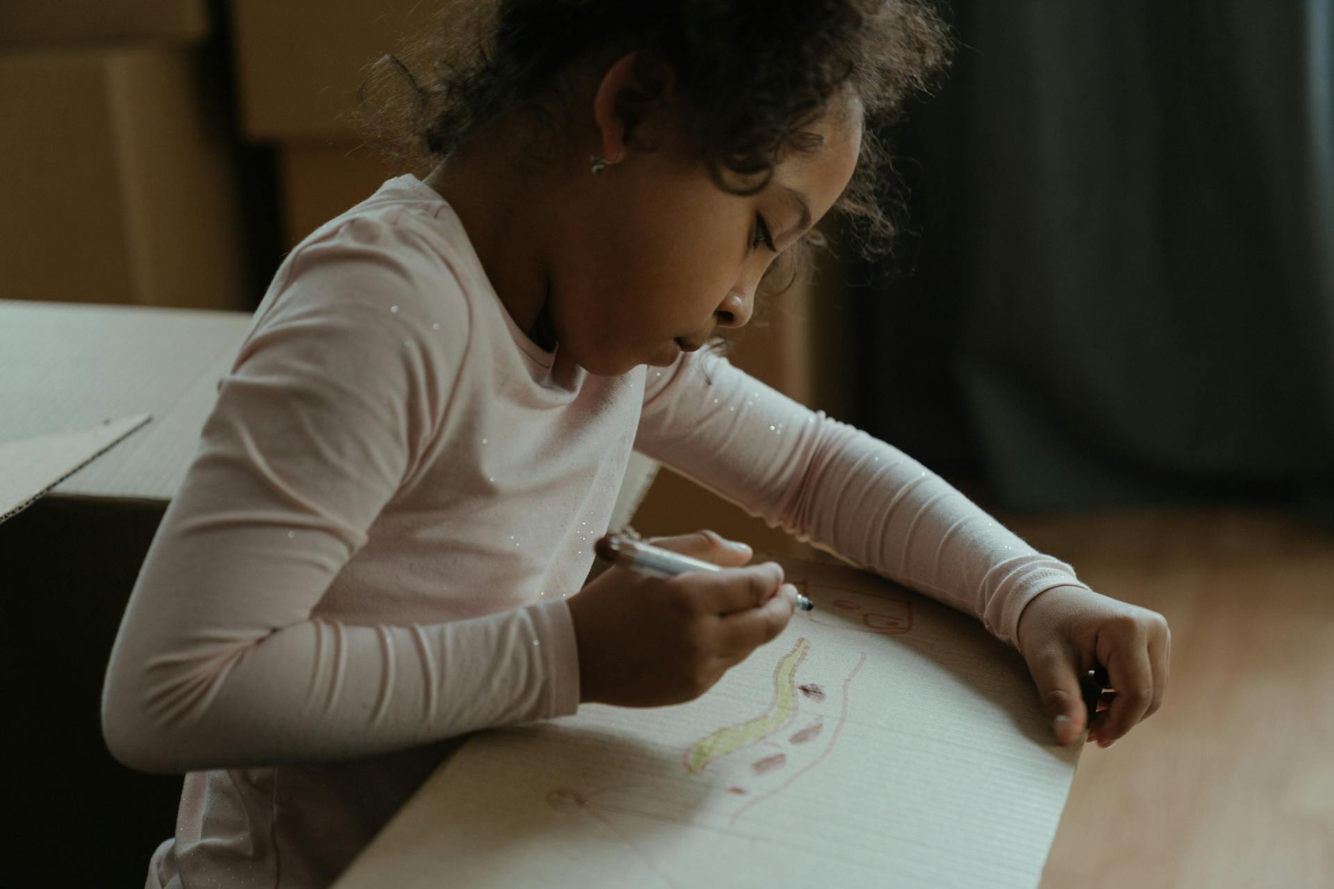 Enfant dessinant sur une boîte | Source : Pexels