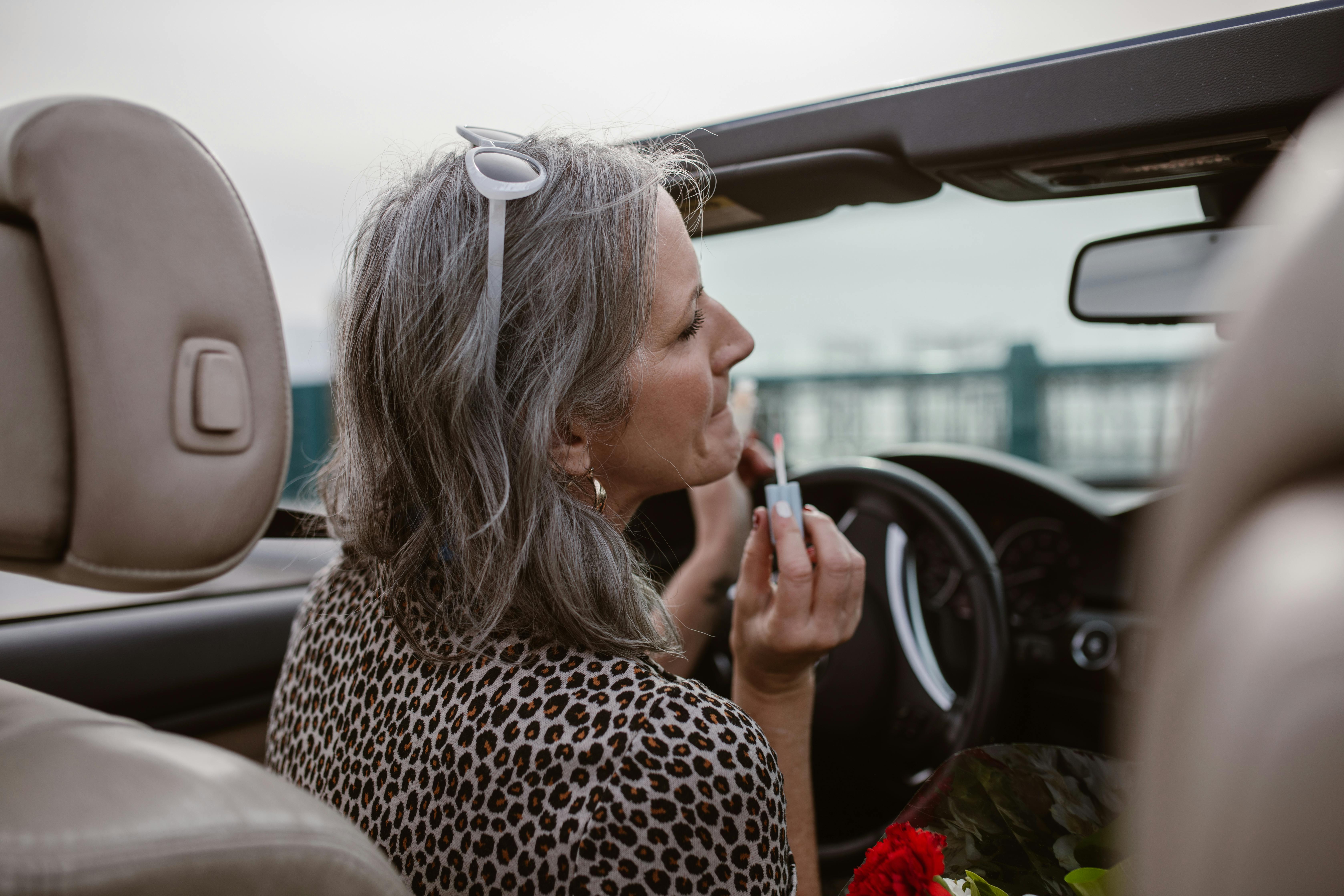Une femme qui applique du rouge à lèvres tout en conduisant | Source : Pexels