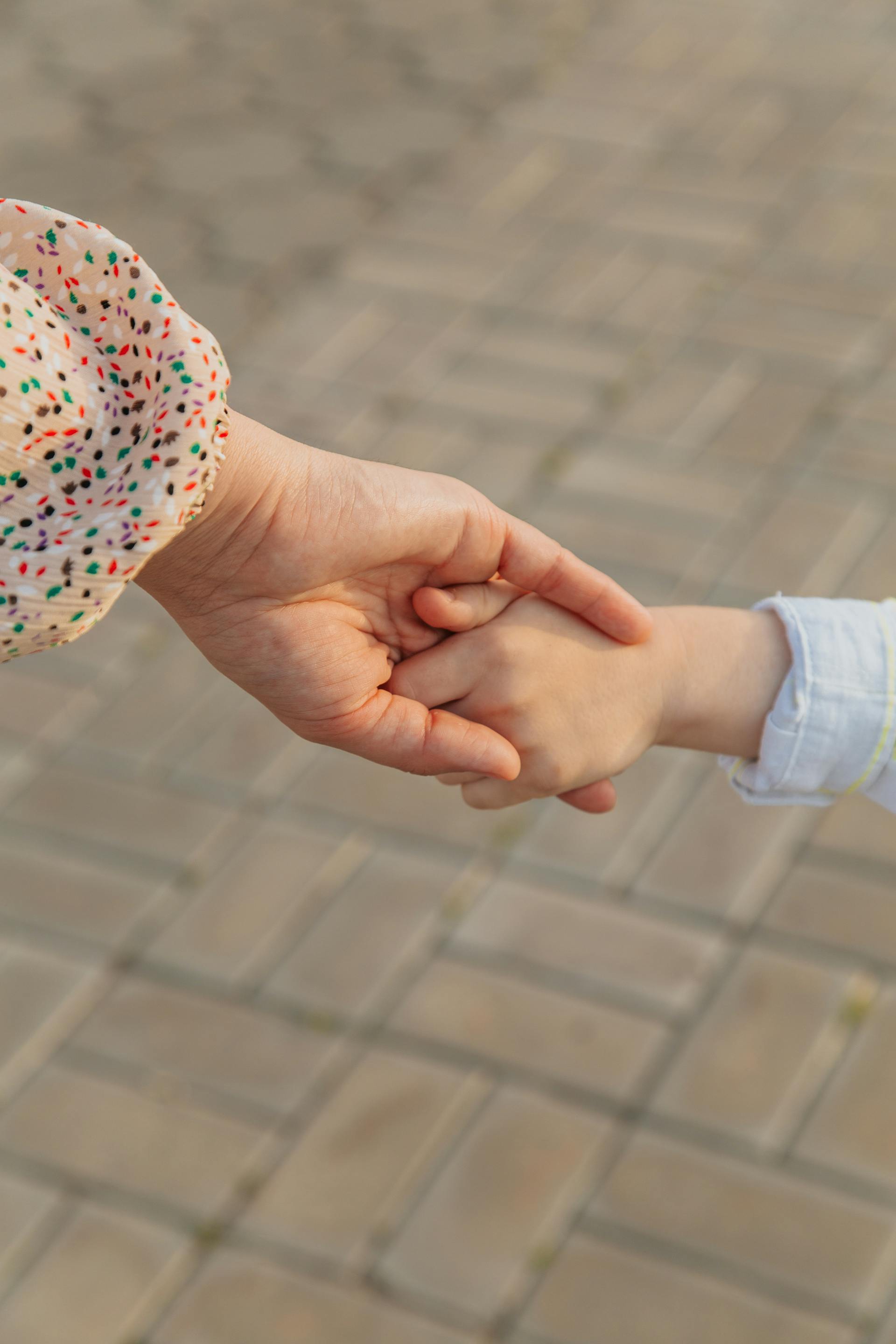 Gros plan d'une femme tenant la main d'un petit enfant | Source : Pexels