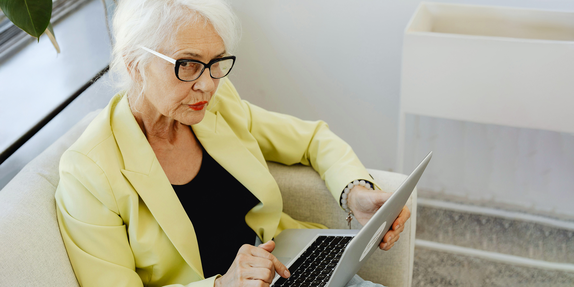 Femme âgée réfléchie travaillant sur son ordinateur portable | Source : Midjourney