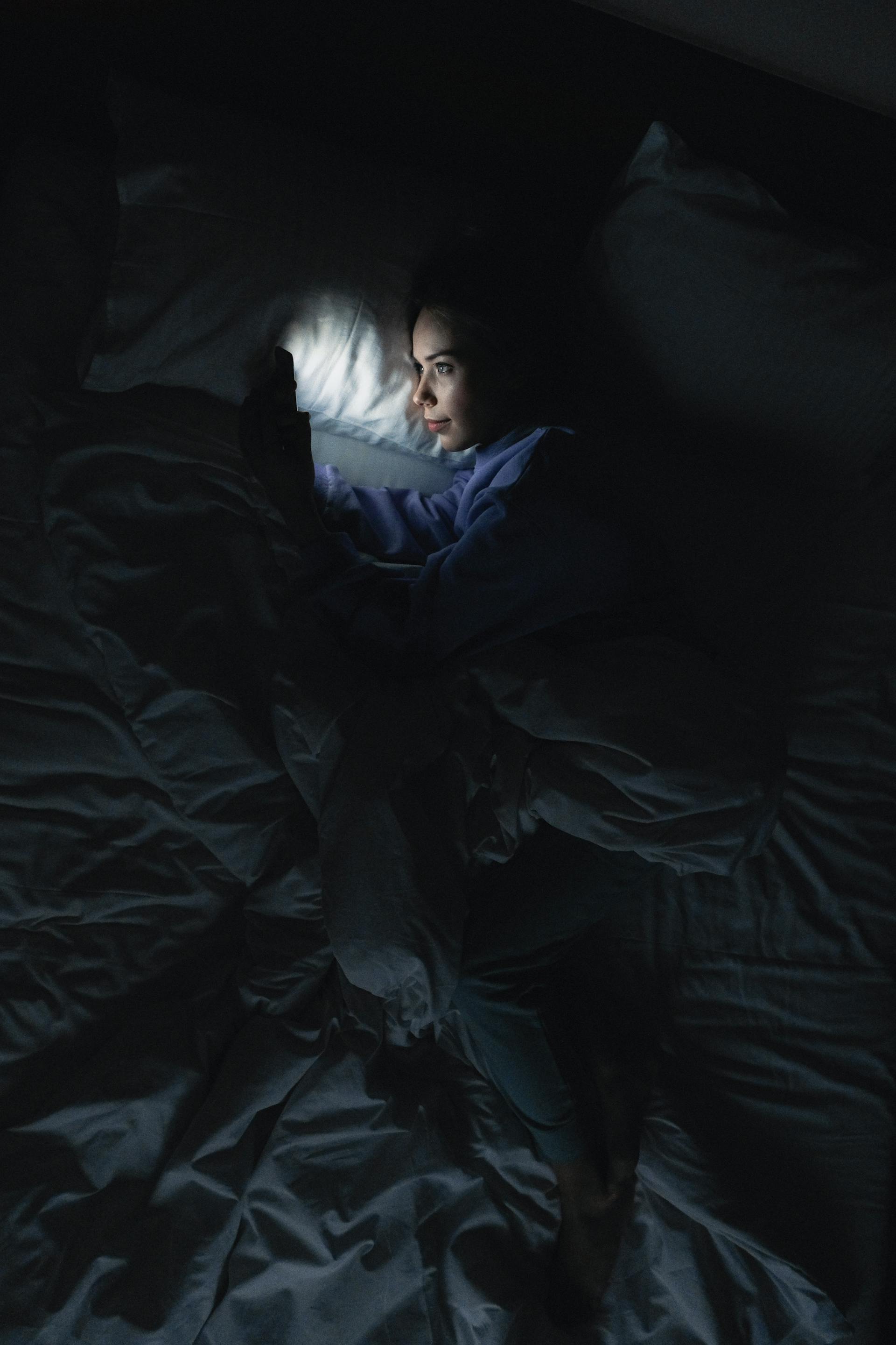 Une femme utilisant son téléphone au lit | Source : Pexels