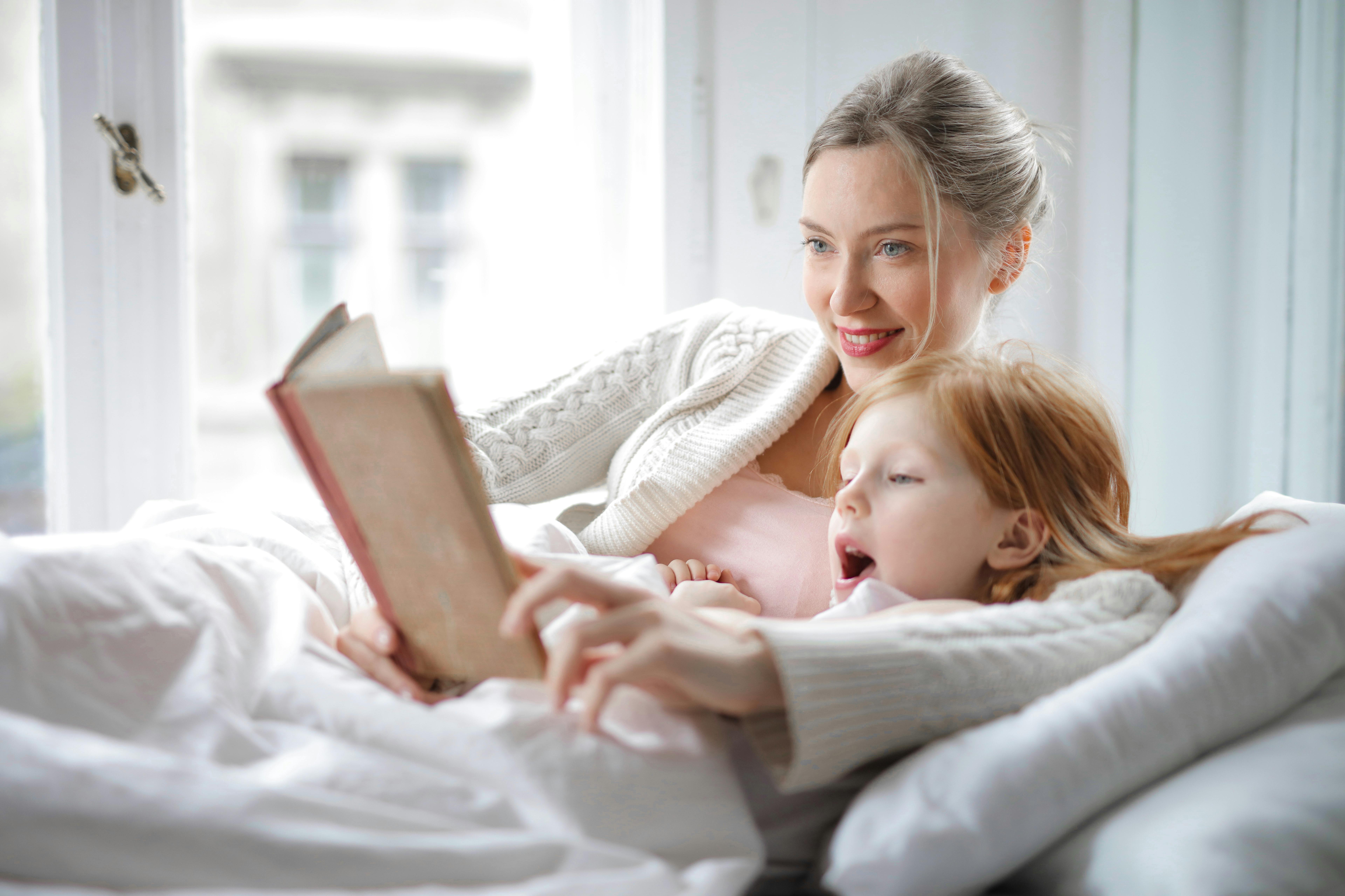 Une femme heureuse et sa fille lisant une histoire | Source : Pexels