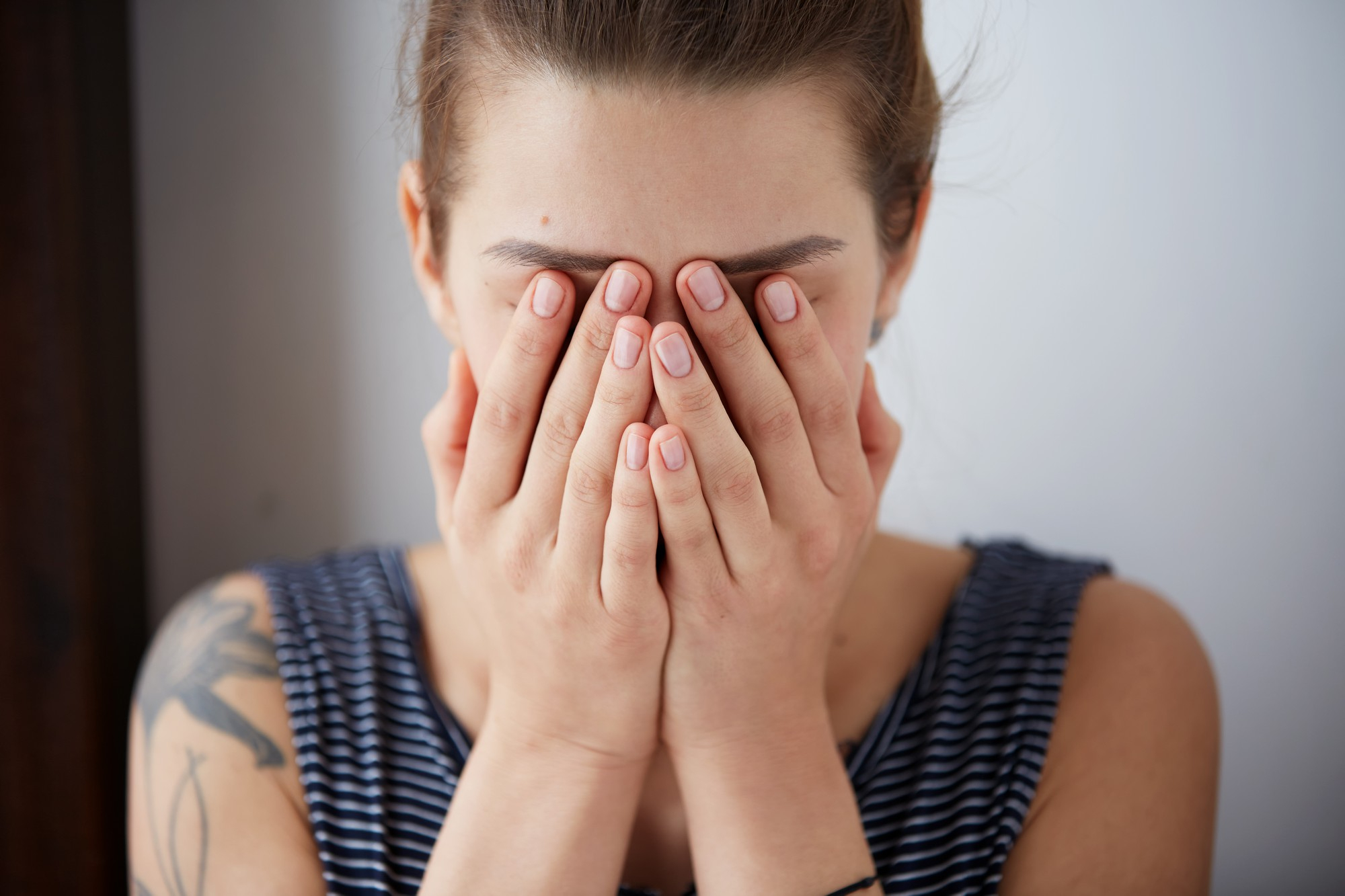 Une femme se couvrant le visage avec ses mains | Source : Freepik