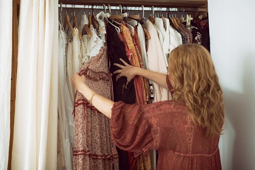 Une femme se tenant devant son placard et choisissant quelque chose à porter. | Photo : Getty Images