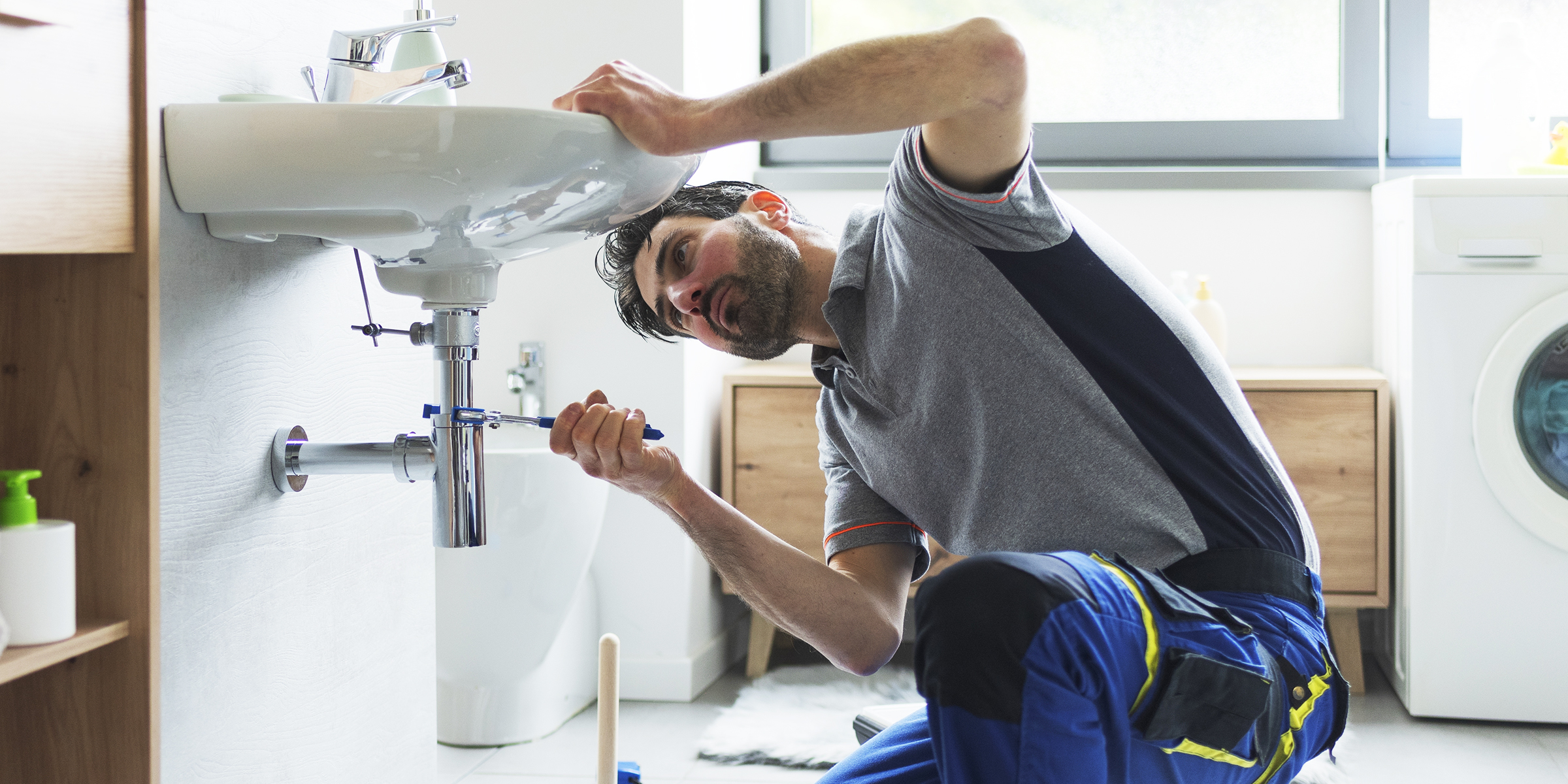 Un plombier en train de réparer un tuyau | Source : Shutterstock