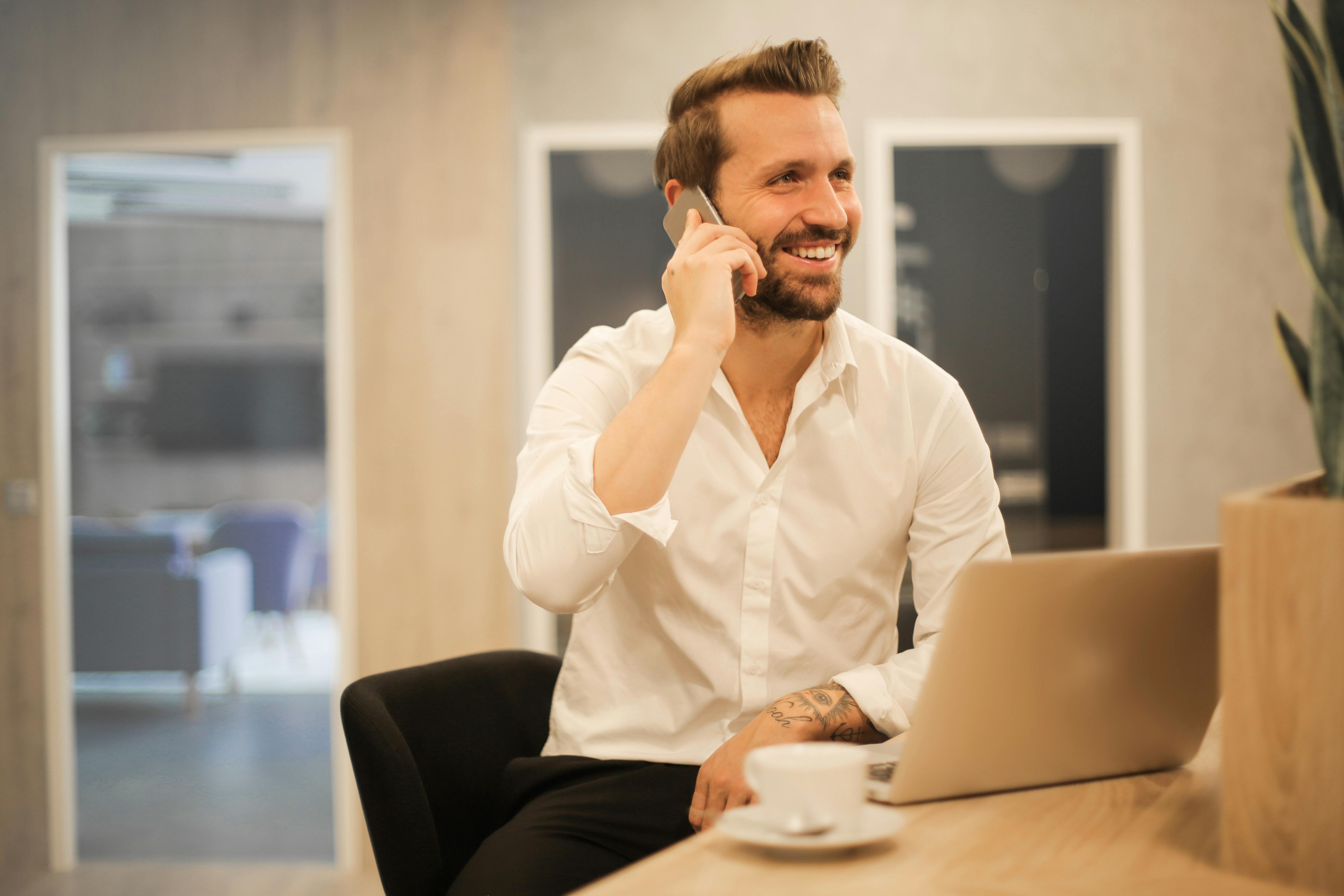 Un homme souriant lors d'un appel | Source : Pexels