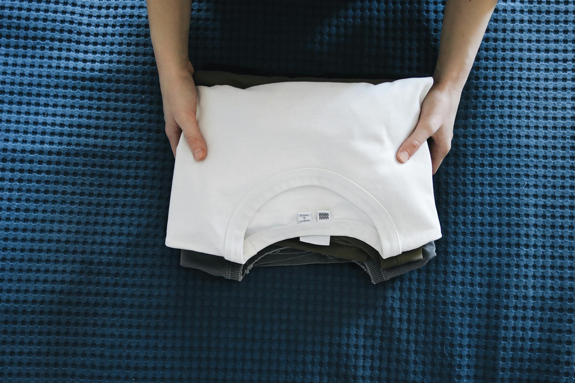 Une personne tenant des t-shirts pliés | Source : Pexels