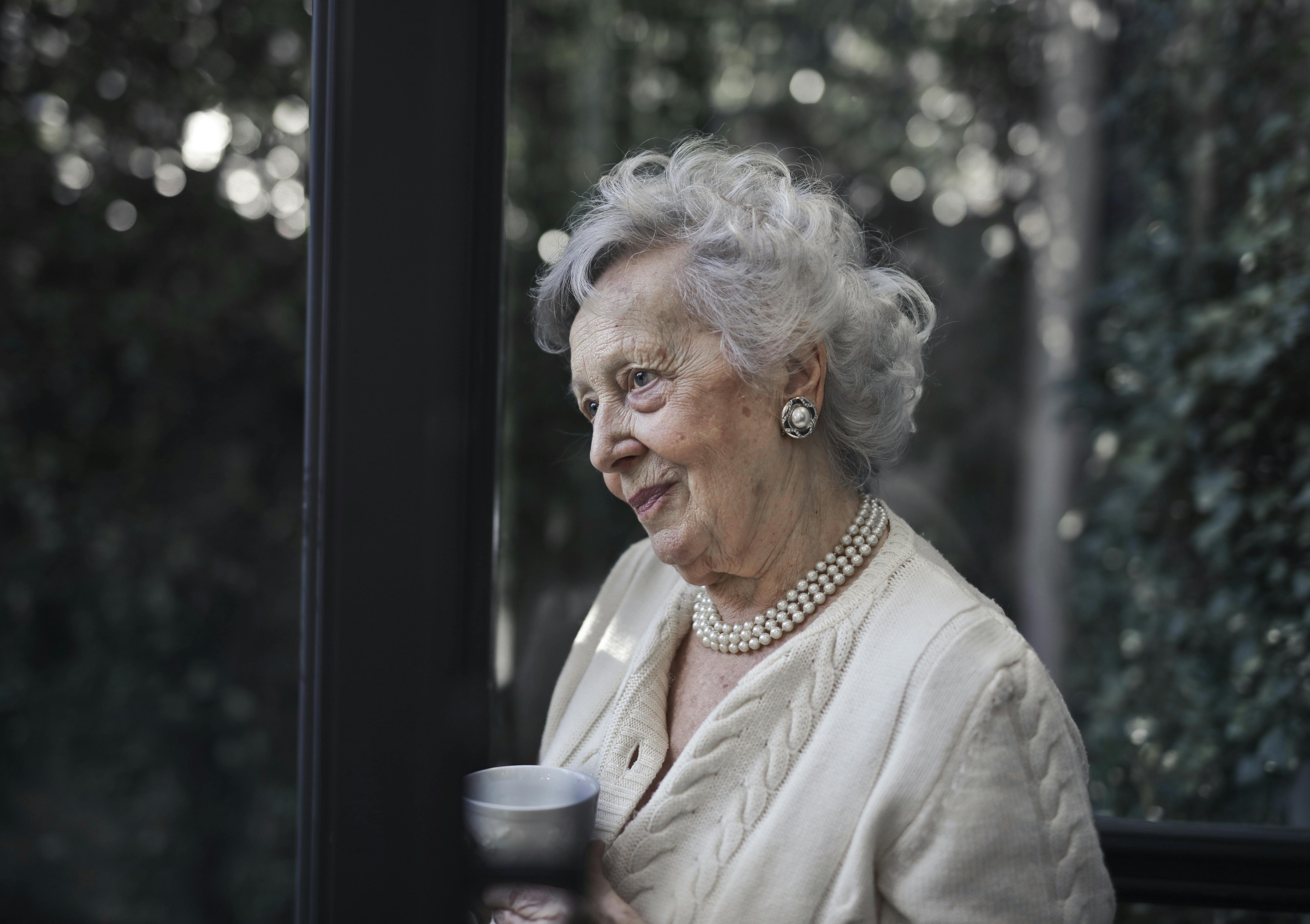 Une femme portant un haut blanc tout en tenant une tasse en céramique | Source : Pexels