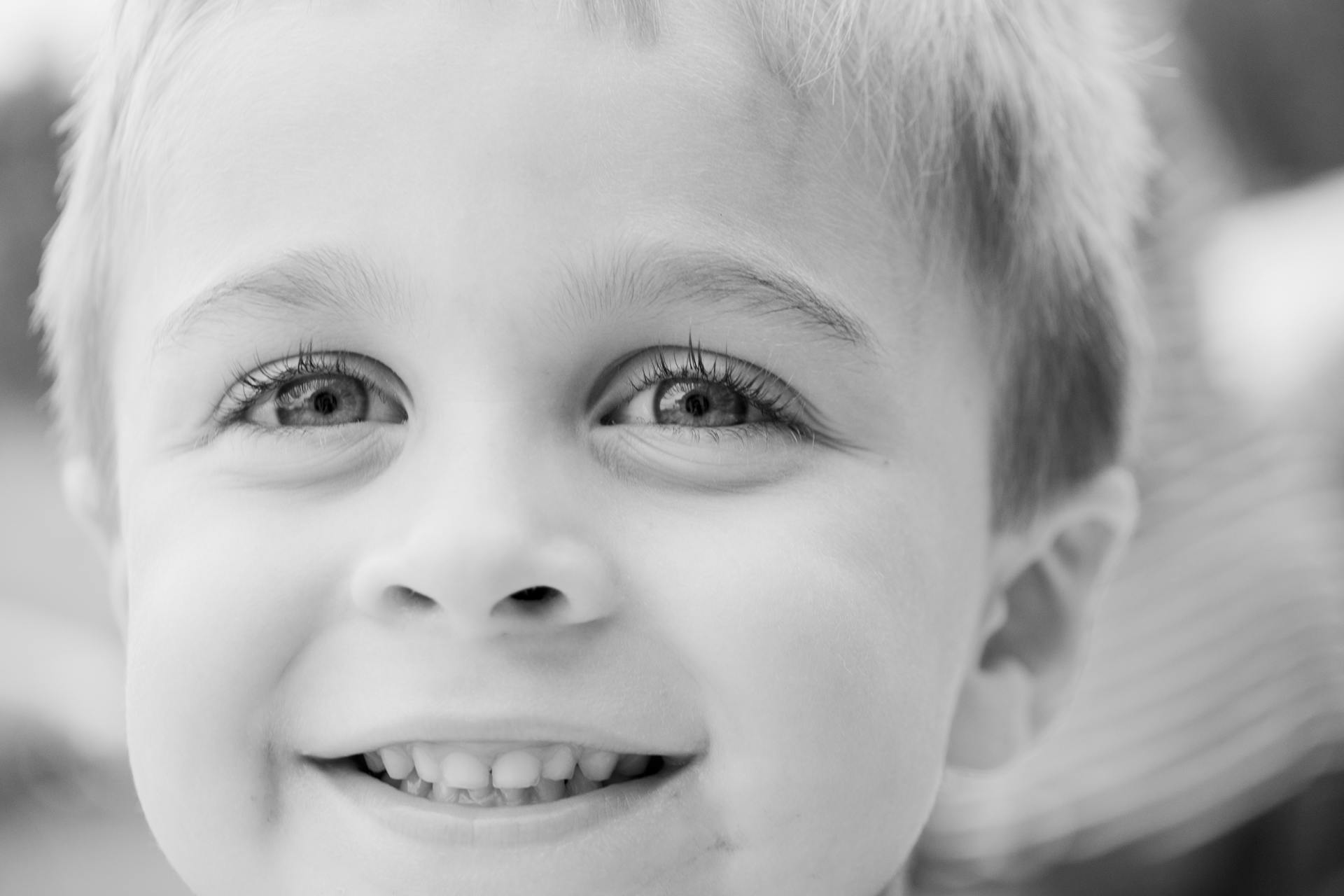 Portrait en niveaux de gris d'un petit garçon souriant | Source : Pexels