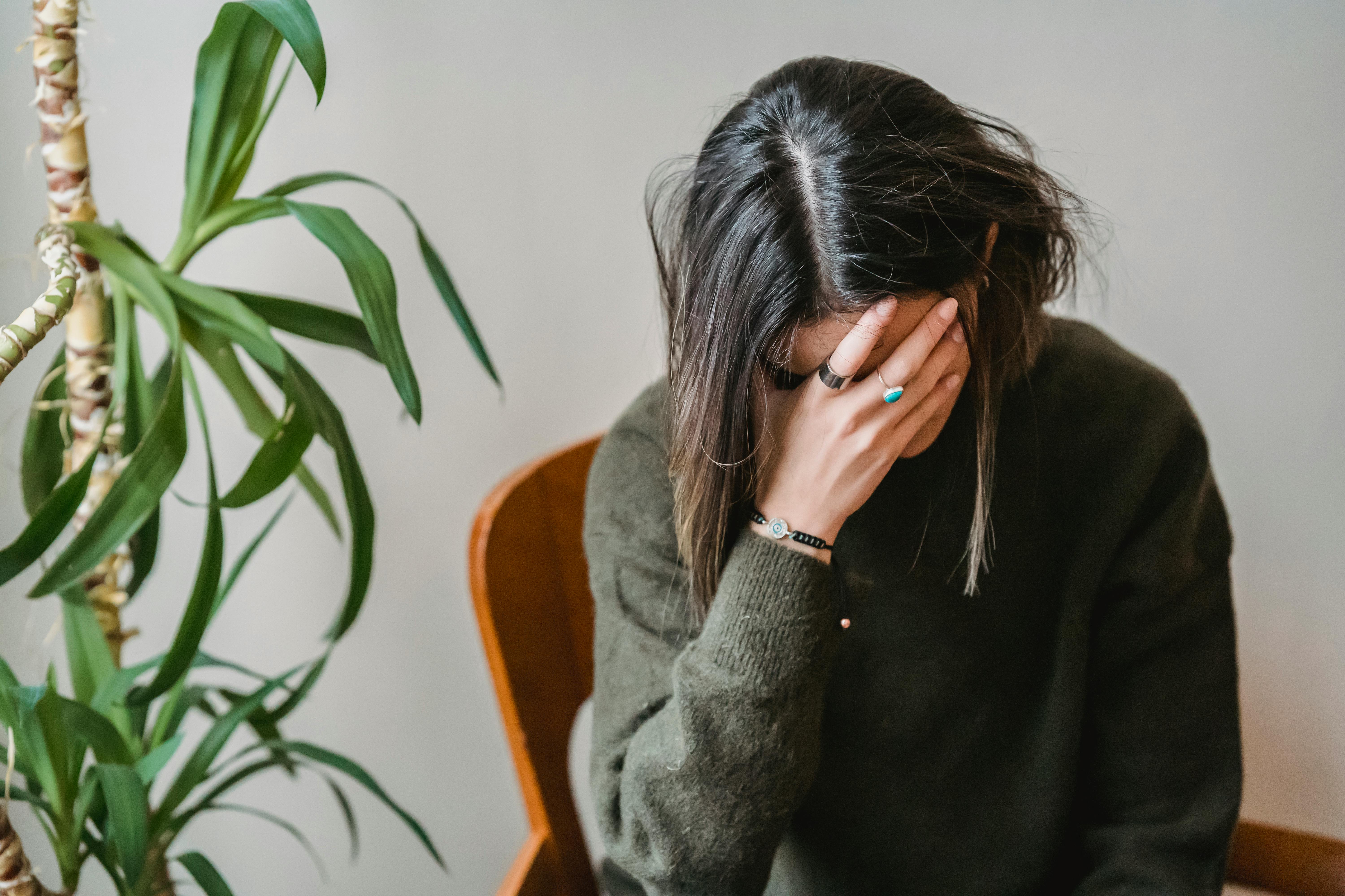 Une femme bouleversée, la tête entre les mains | Source : Pexels