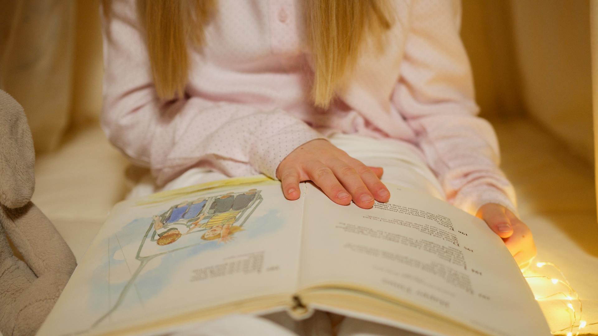 Une petite fille lisant un livre | Source : Pexels