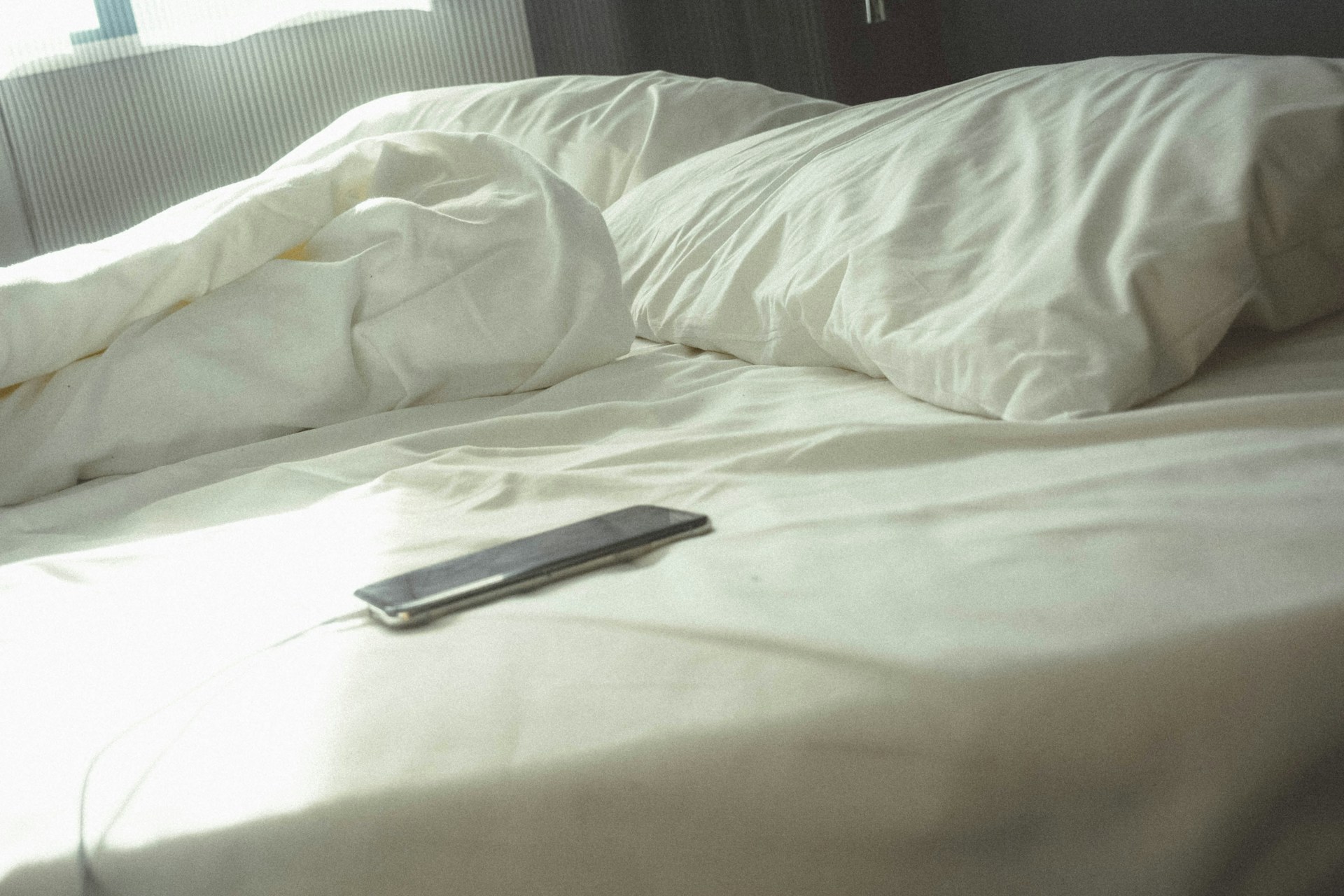 Un téléphone sur le lit | Source : Unsplash