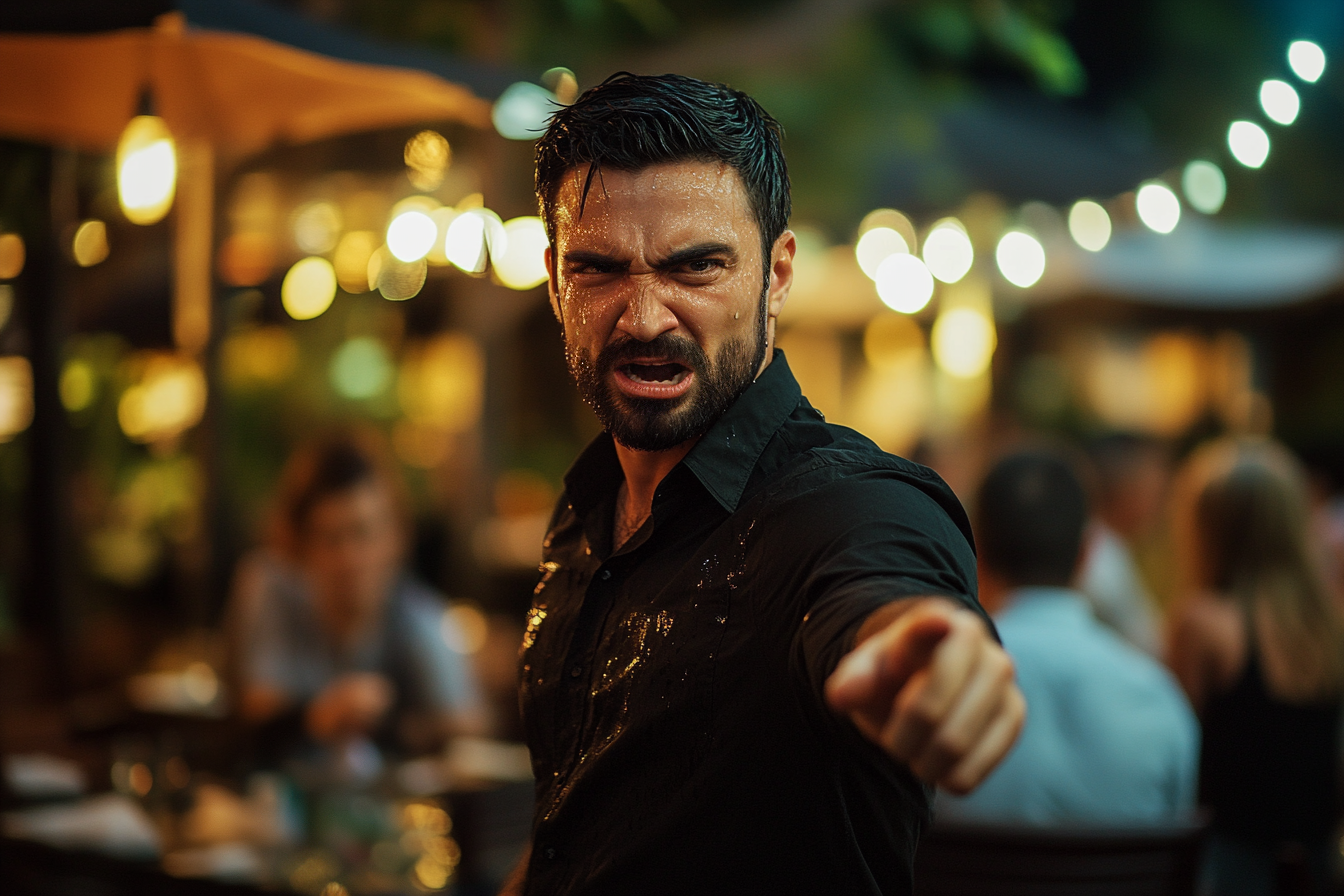 A man covered in soda yells and points angrily while standing in a restaurant | Source: Midjourney