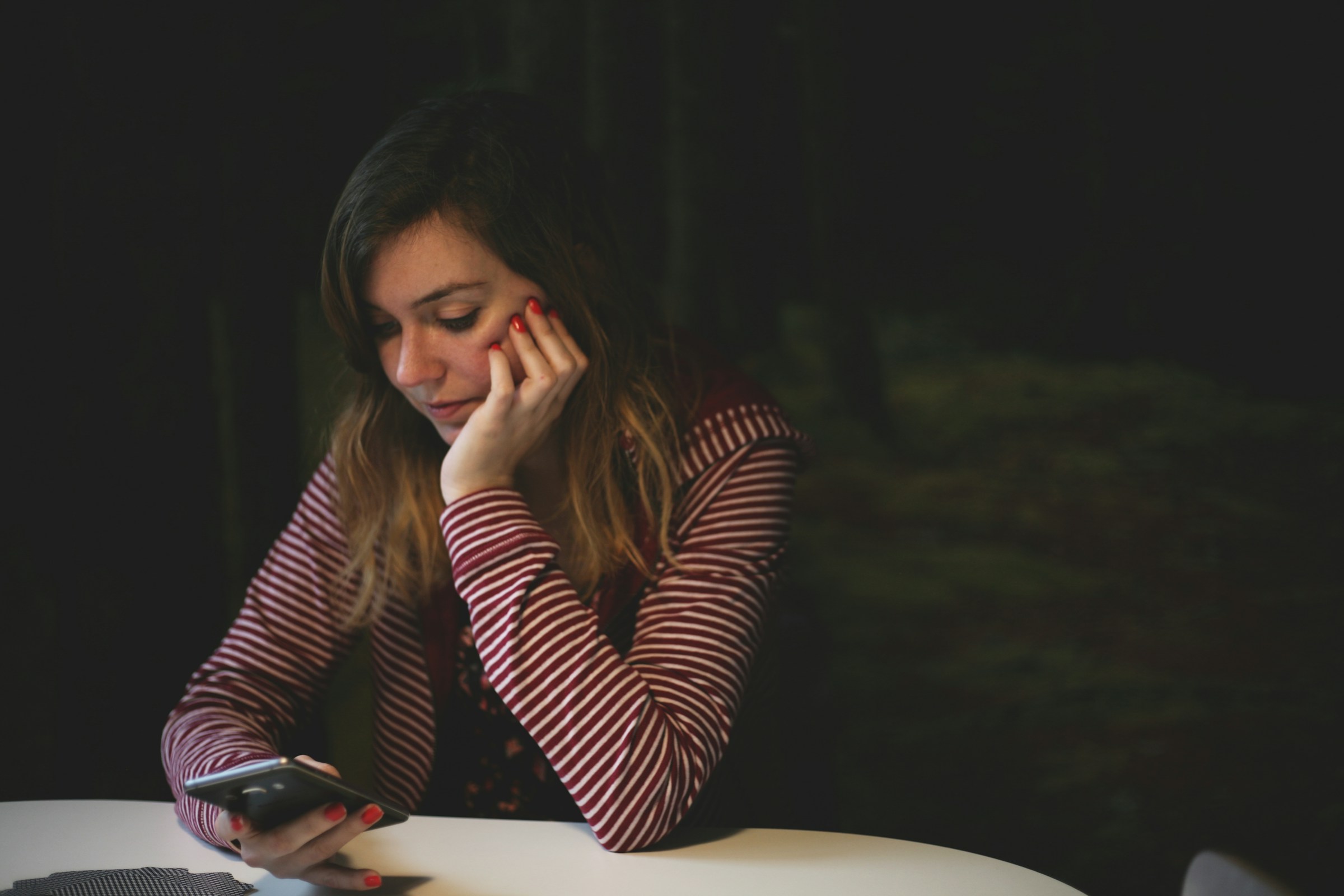 Une femme qui regarde fixement son téléphone | Source : Unsplash