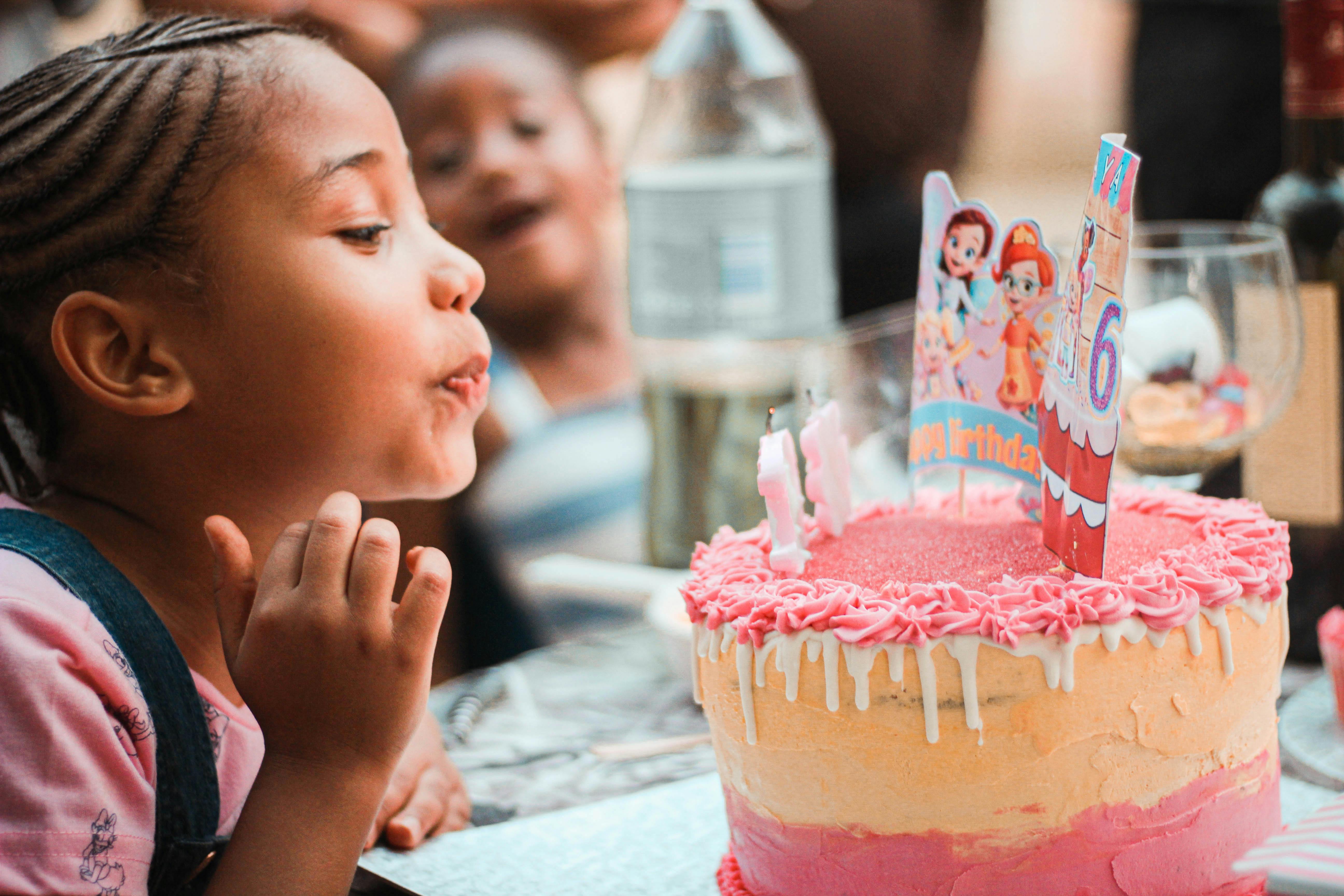 Une fille qui souffle les bougies sur son gâteau | Source : Pexels