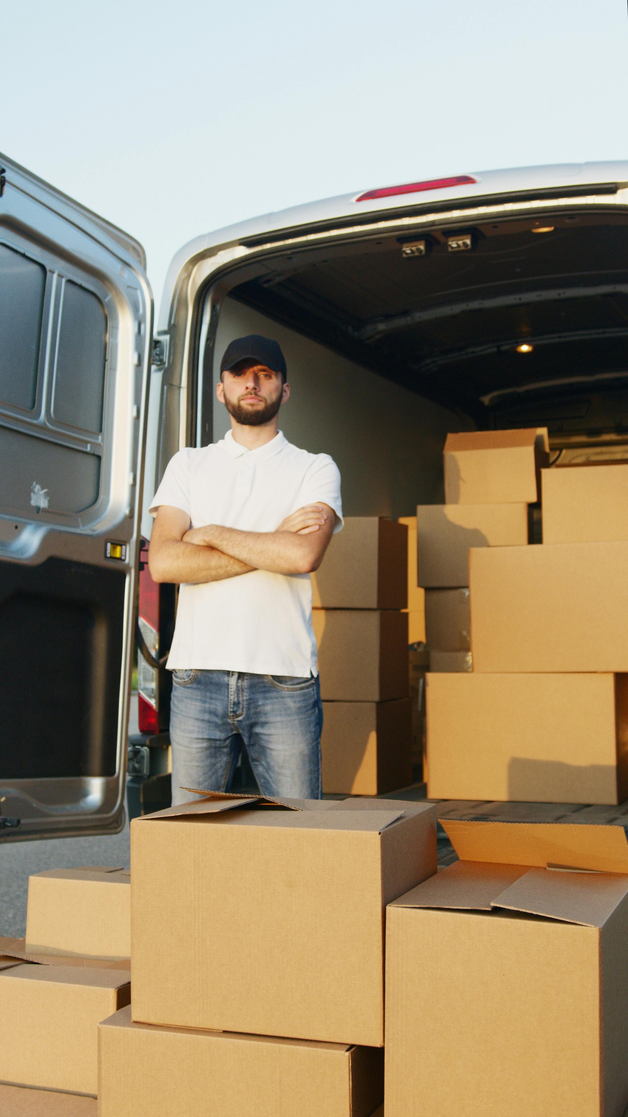 Un homme photographié à côté de cartons | Source : Pexels
