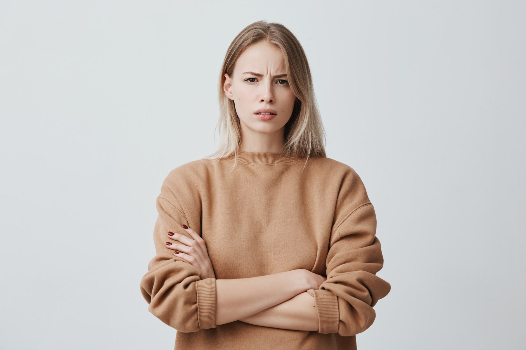 Une femme sérieuse avec les bras croisés | Source : Freepik