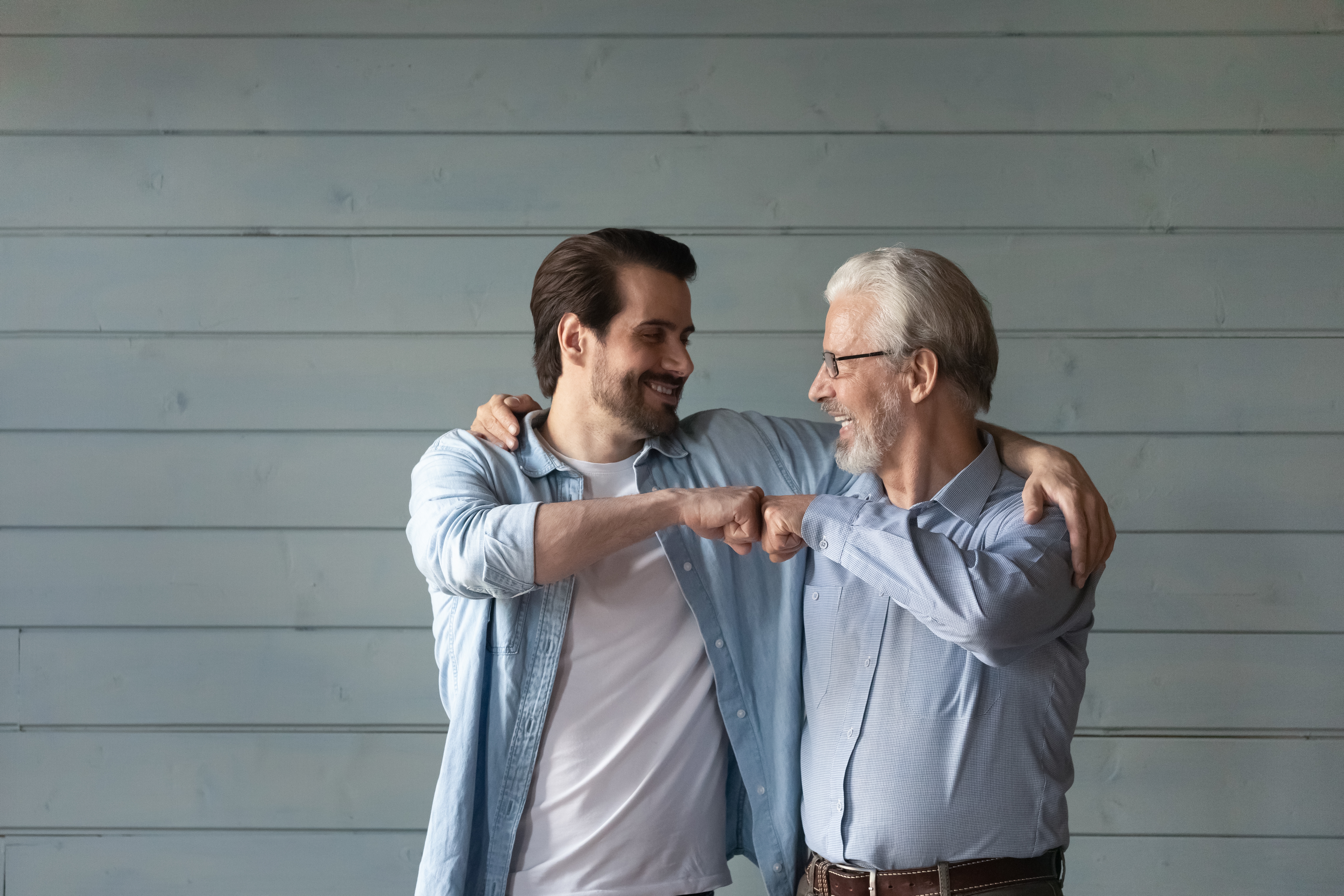 Un homme plus âgé tape du poing avec un homme plus jeune | Source : Shutterstock